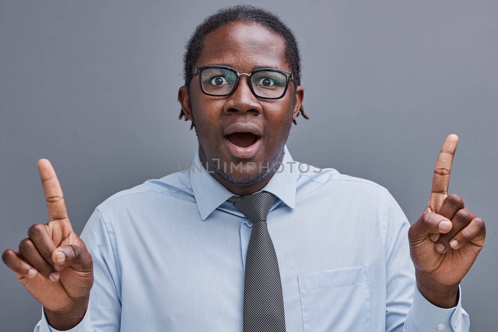 young african american man surprised showing fingers up on gray background by Prosto