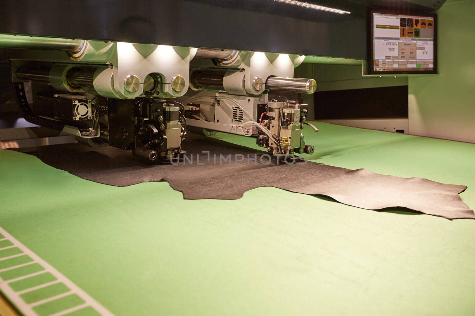 Image of robotic machine cutting leather for parts, close-up