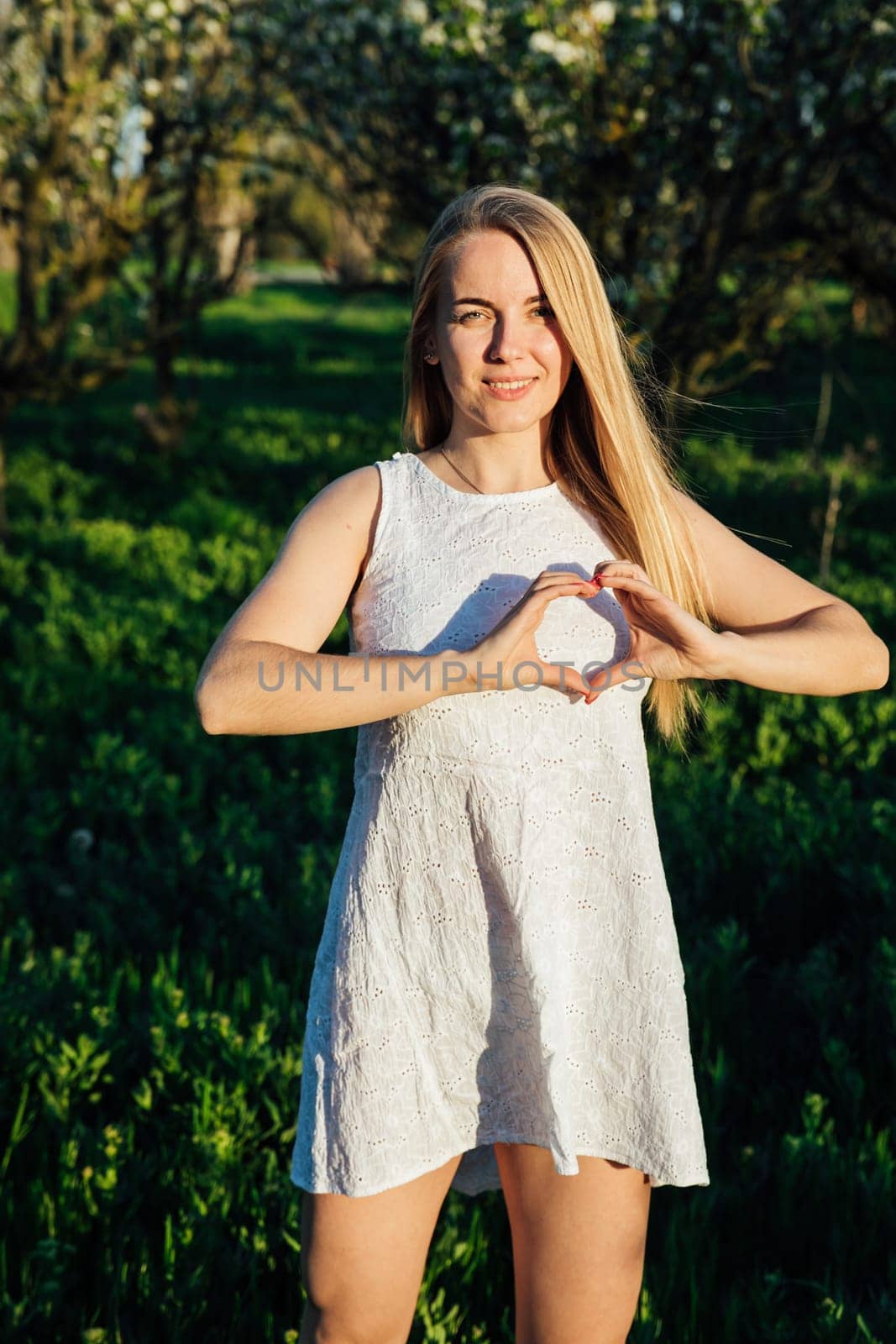 blonde woman showing her heart with her hands