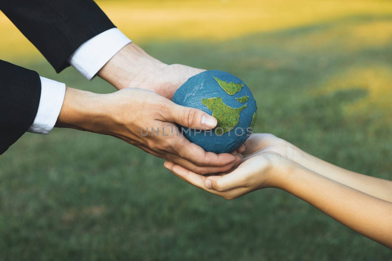 Businessman hand giving Earth globe to little boy as Earth day concept as corporate social responsible to contribute greener environmental protection for sustainable future generation. Gyre