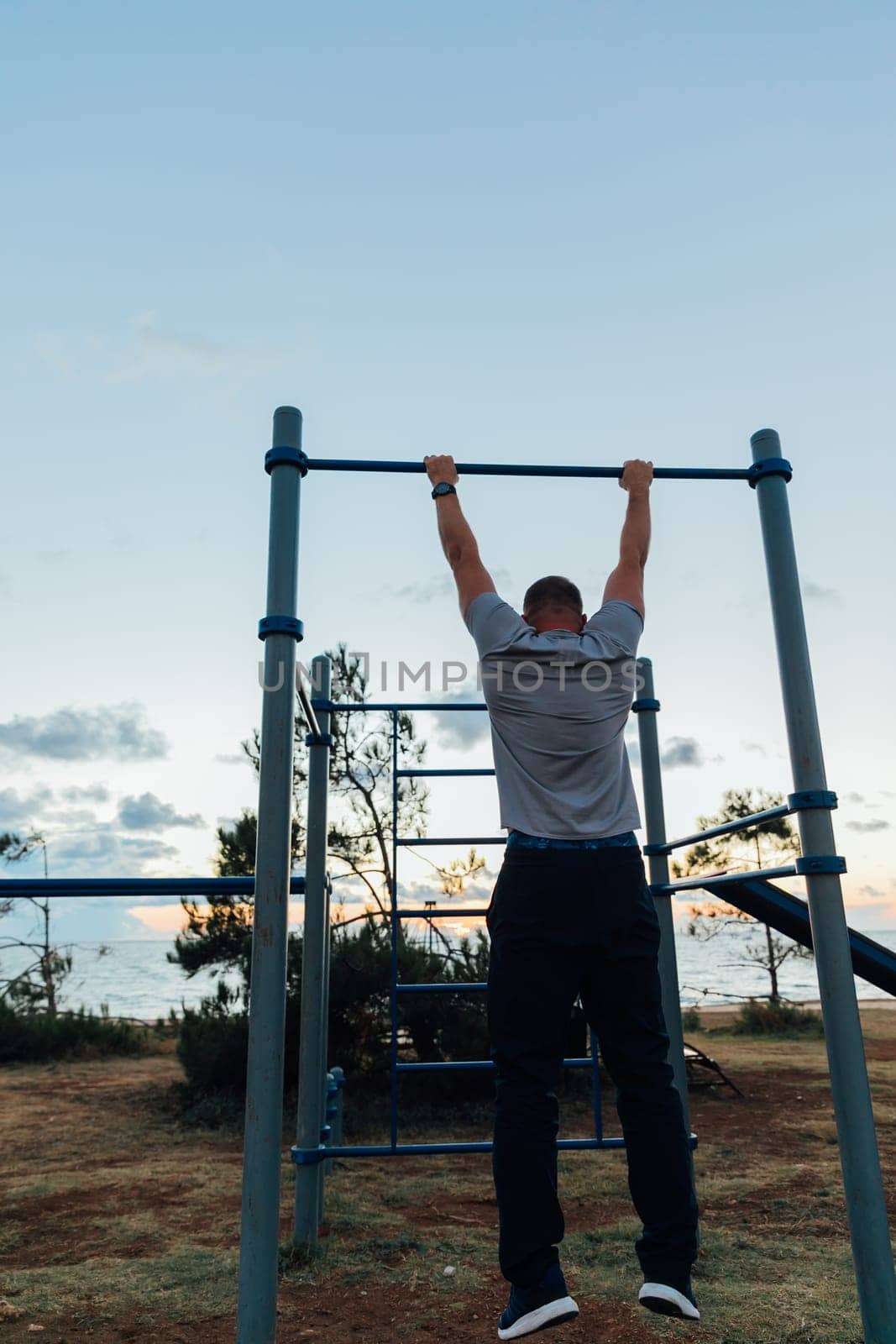 man pulls up on pull-up bar