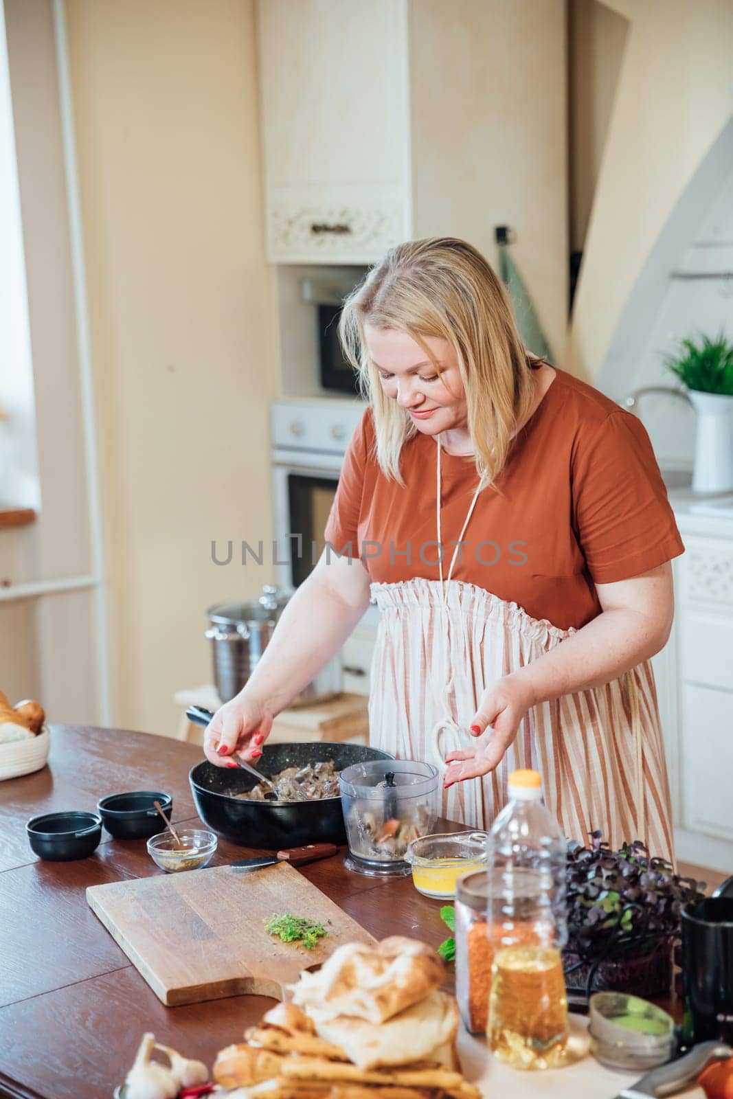 Woman cook at home in kitchen preparing delicious food by Simakov