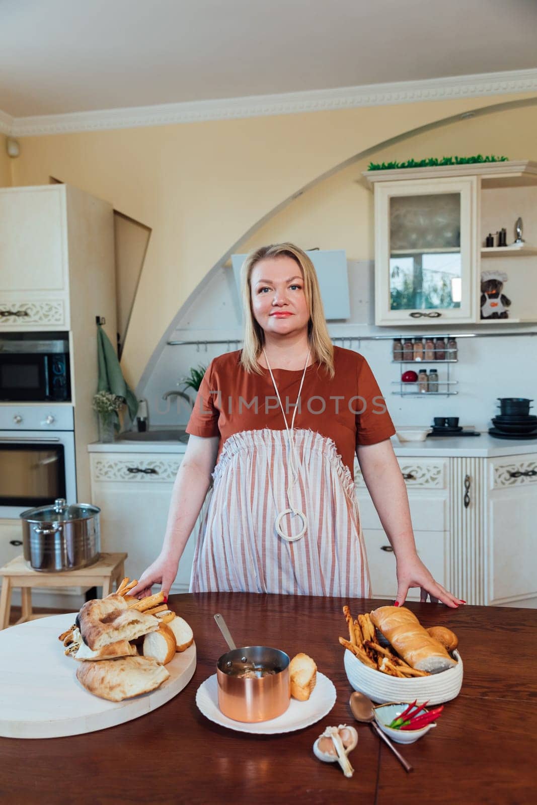 Female housewife prepares delicious food in kitchen from products by Simakov