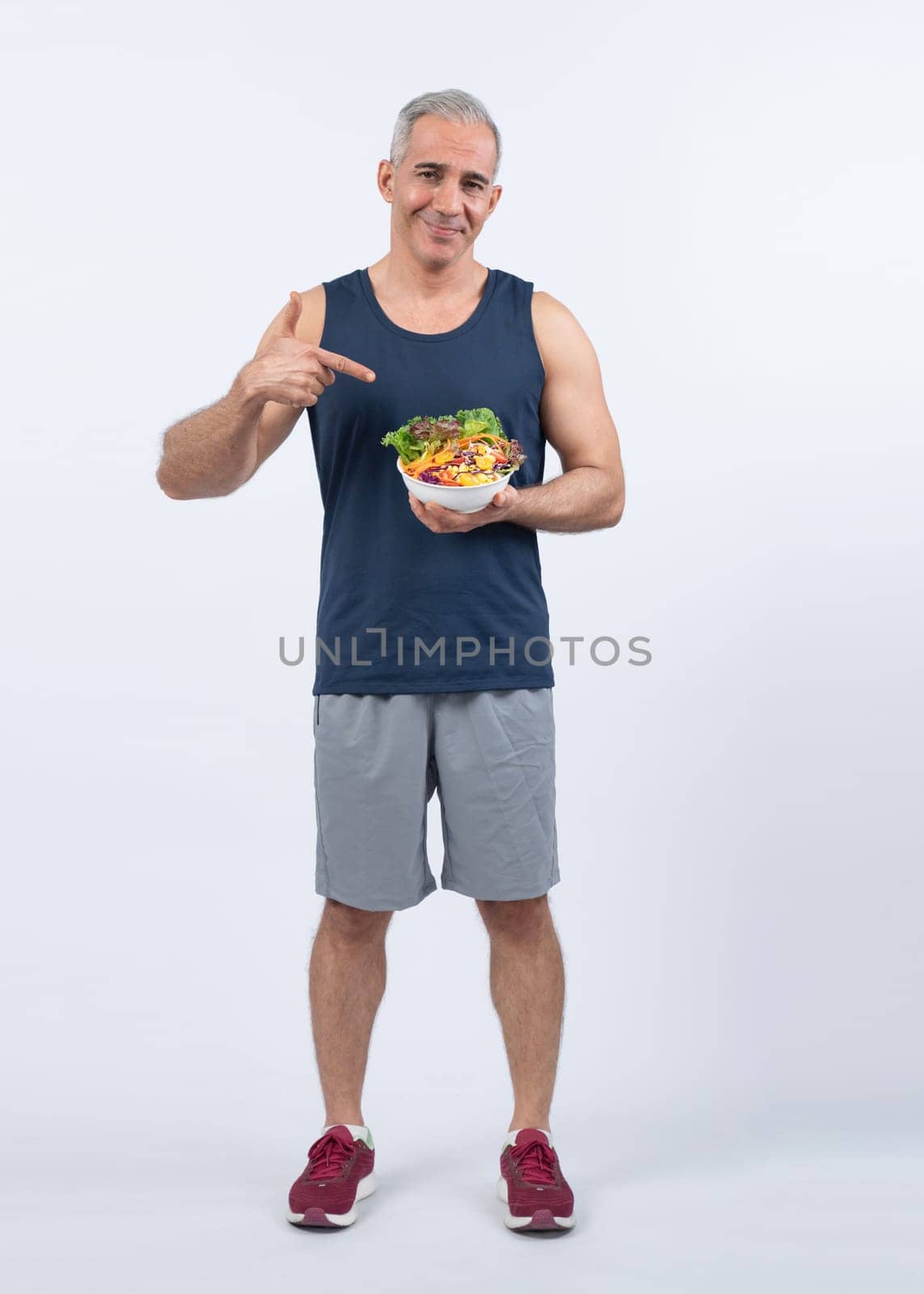 Happy smile senior man portrait holding bowl of vegan fruit and vegetable on isolated background. Healthy senior people with healthy vegetarian nutrition and body care lifestyle. Clout