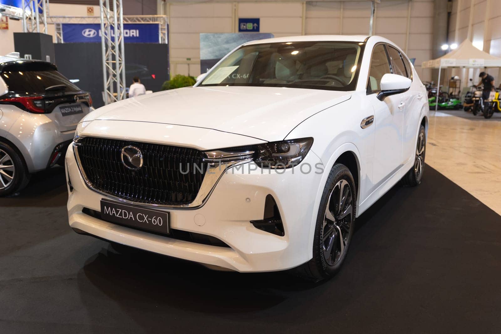12 MAY 2023, Lisbon, Porugal, Electric car Show in International Fairy of Lisbon - : A Showcase of a White Car in a Modern Showroom by Studia72