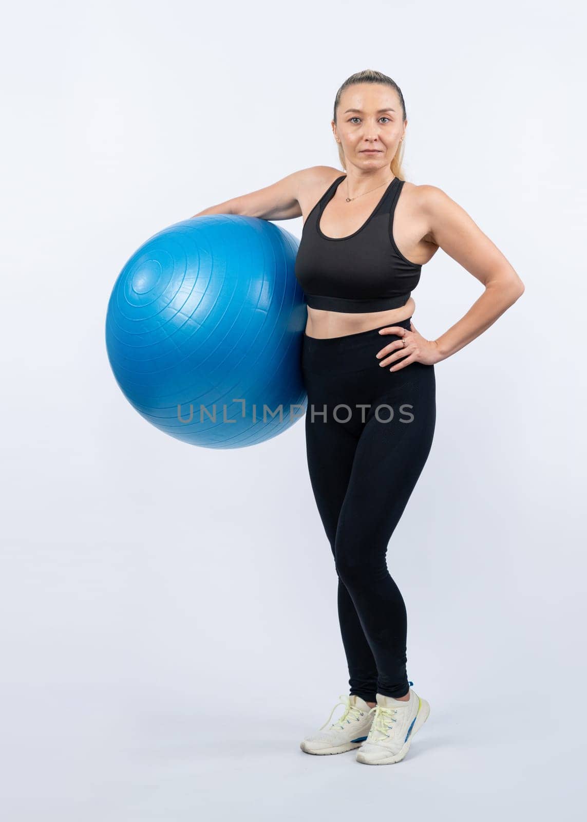 Full body length shot athletic and sporty senior woman with fitness exercising ball on isolated background. Healthy active and body care lifestyle after retirement. Clout