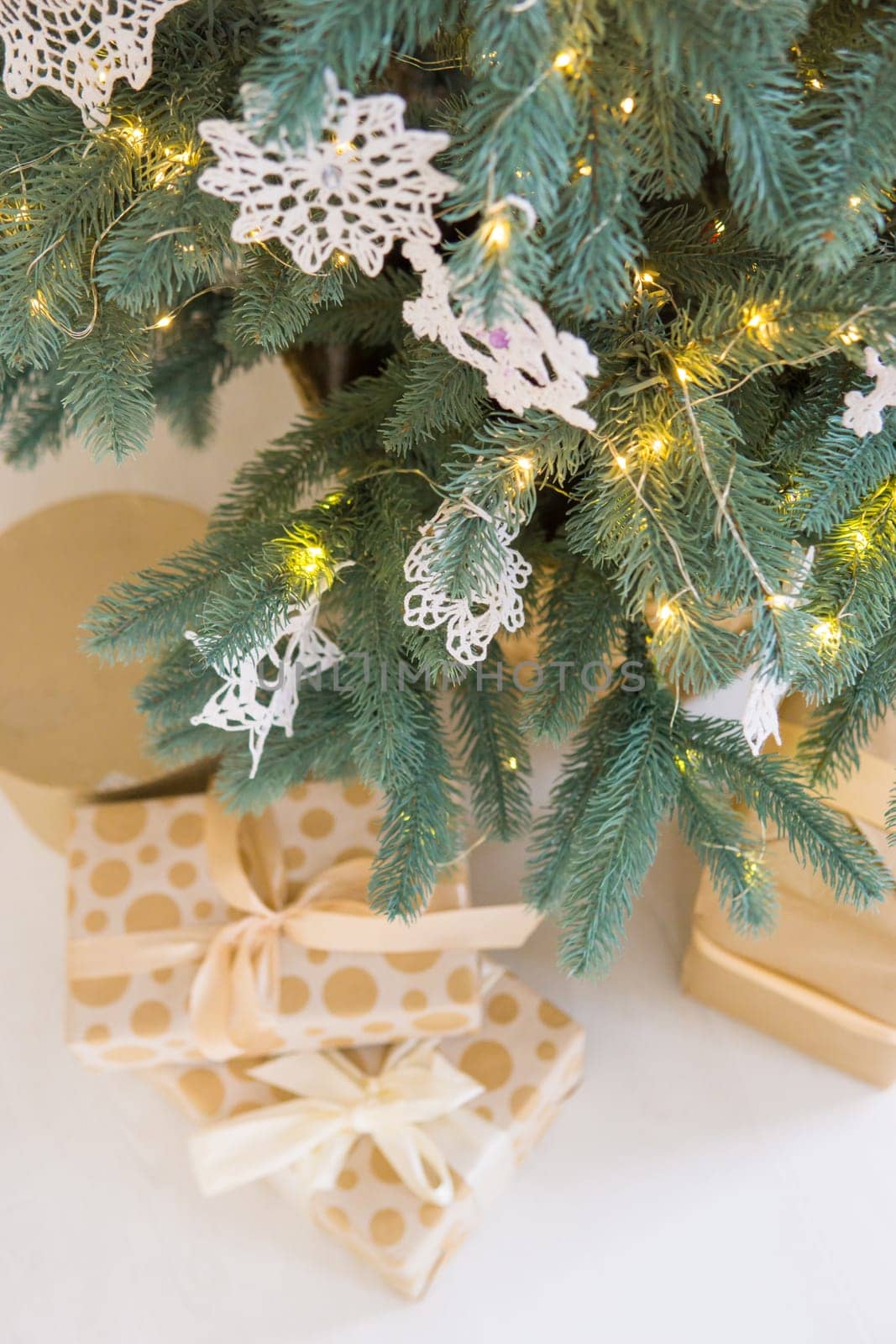 Macrame-style Christmas toys are hanging on the Christmas tree. Toys in the form of snowflakes. Handmade eco-style decor. New Year and eco-friendly concept