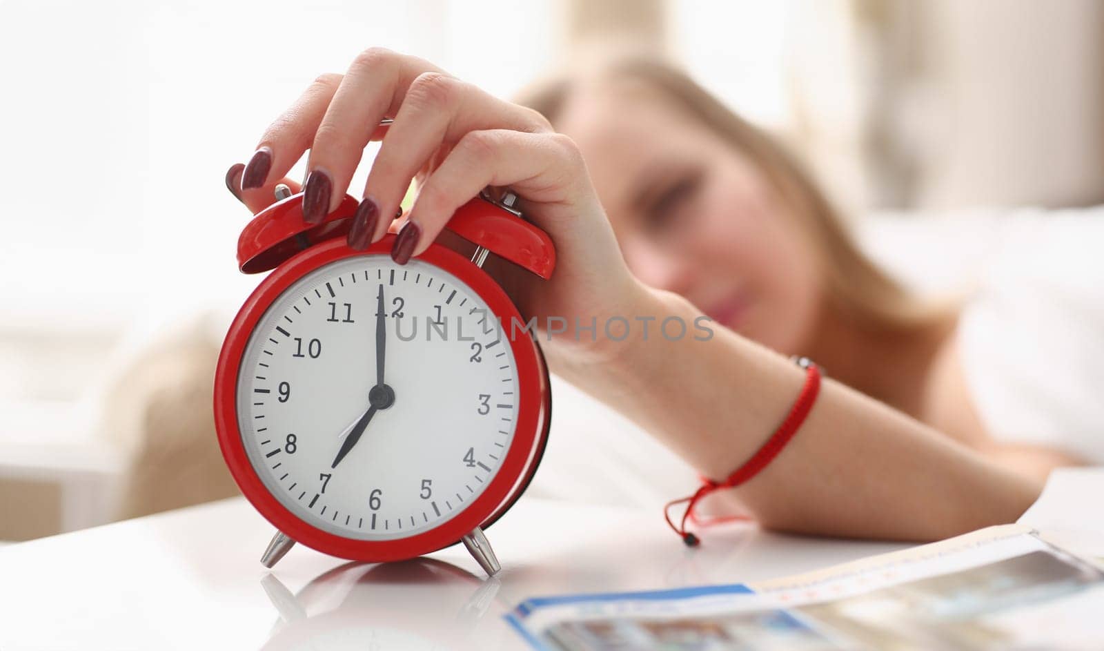 Young beautiful woman waking up in the morning alarm concept