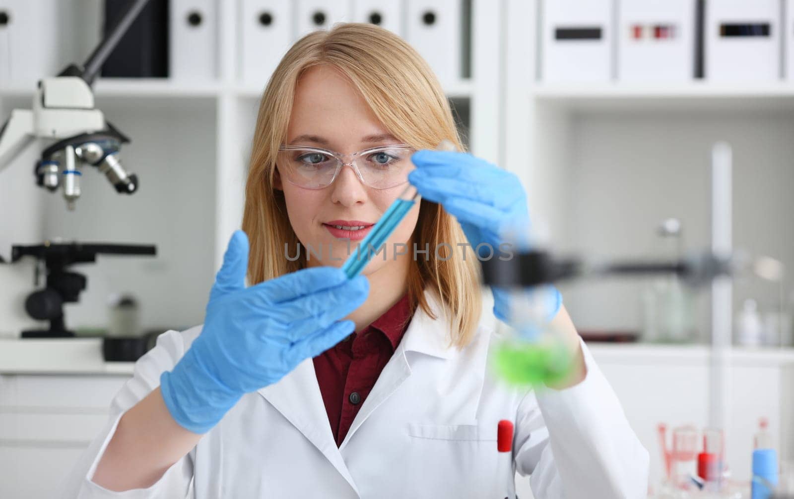 Technician hold in arms in protective gloves sample bottle with poison fluid portrait. Medical worker in uniform use reagent tube for virus infection exam or biological toxic reaction drug creation