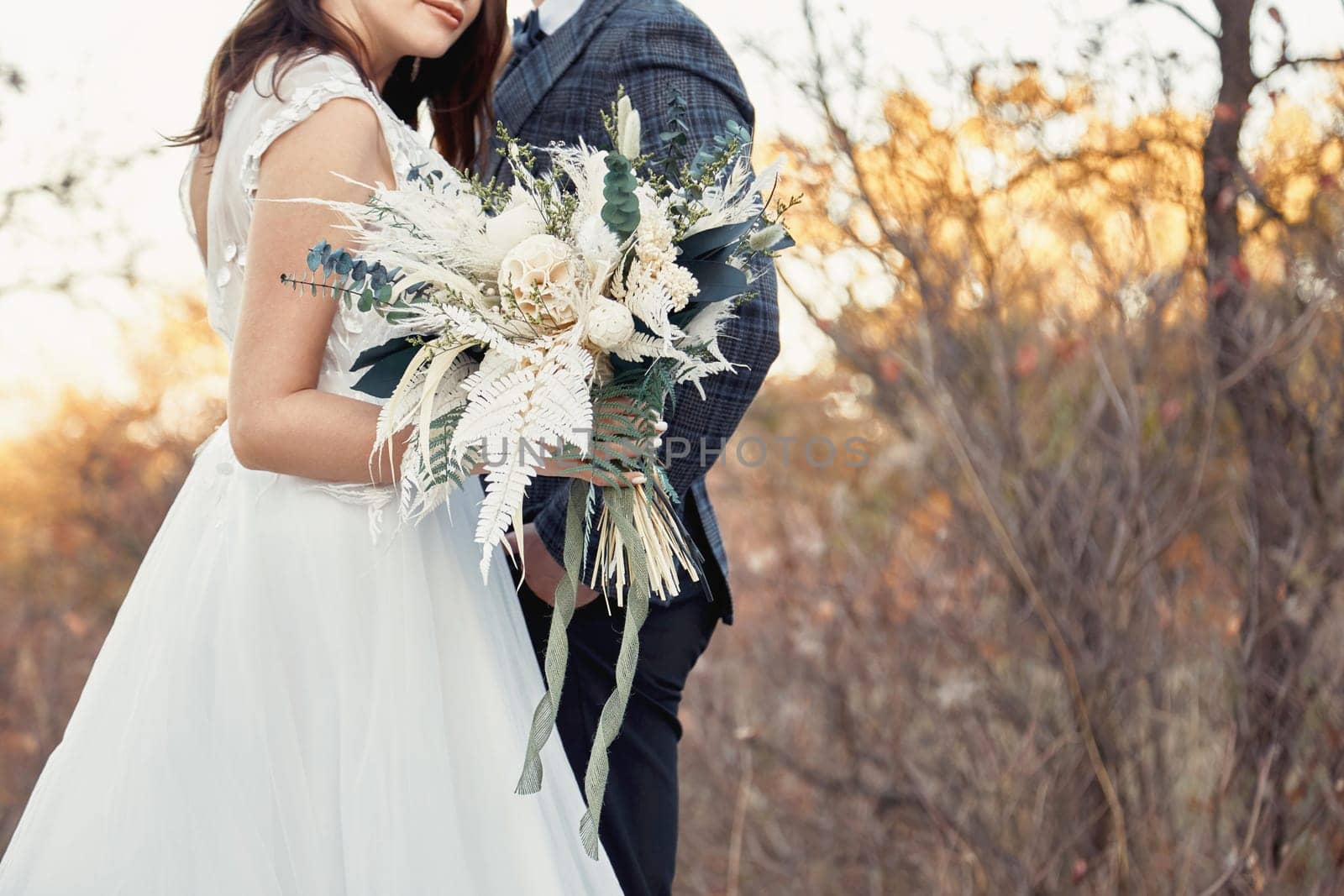 bride and groom holding a beautiful bouquet by erstudio