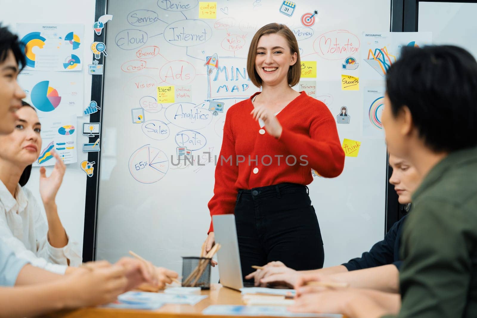 Professional attractive female leader presents creative marketing plan by using brainstorming mind mapping statistic graph and colorful sticky note at modern business meeting room. Immaculate.