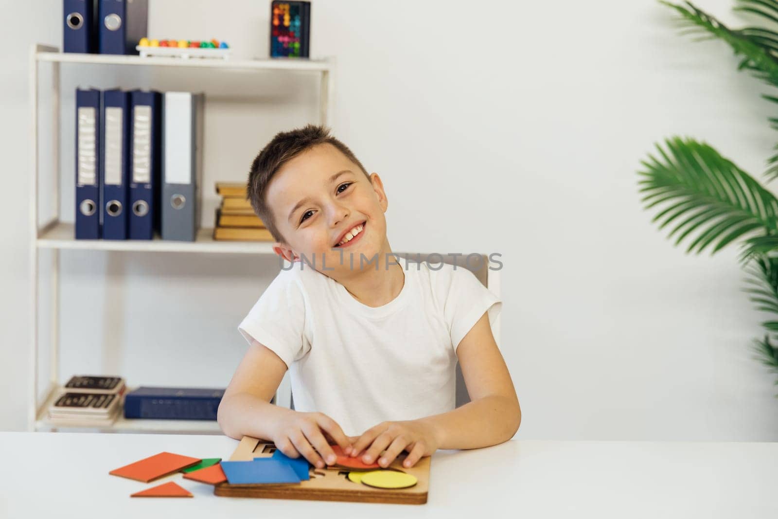 A boy in a teacher's office is engaged in developmental classes