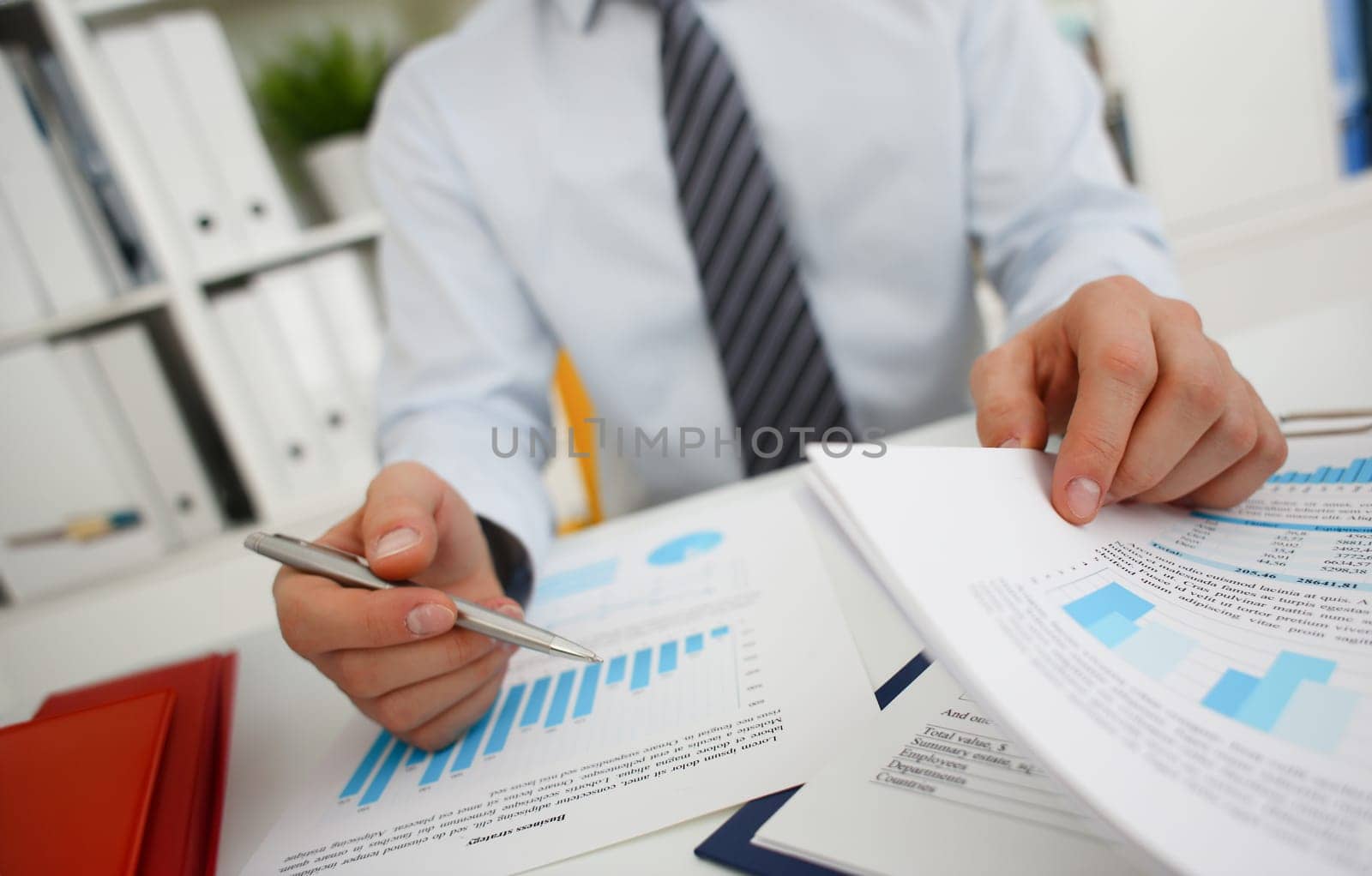 Male hands hold documents with financial statistics at office workspace closeup. White collar check money papers stock exchange market internal Revenue Service inspector earning list concept