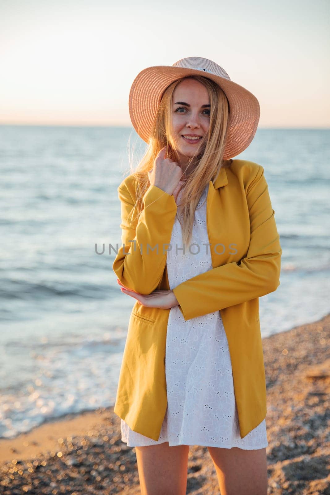 blonde woman in a hat on a walk by the sea on the shore Rest