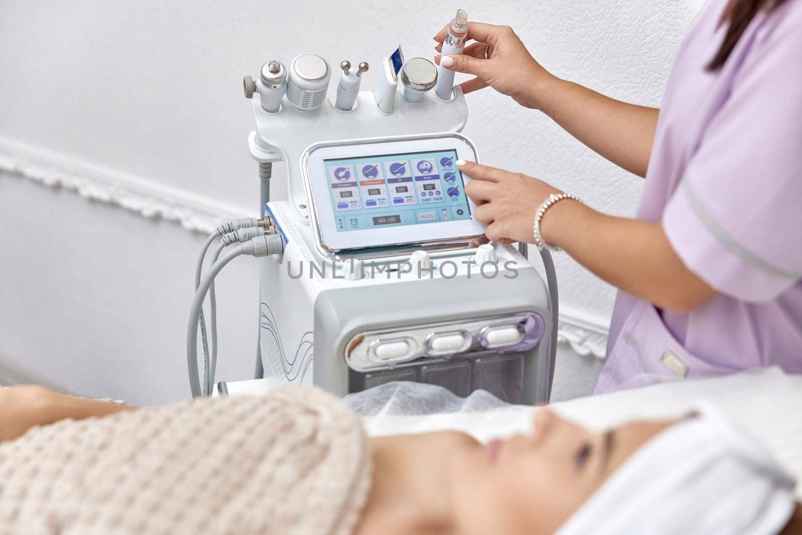beautician using cosmetology equipment in modern aesthetic clinic.