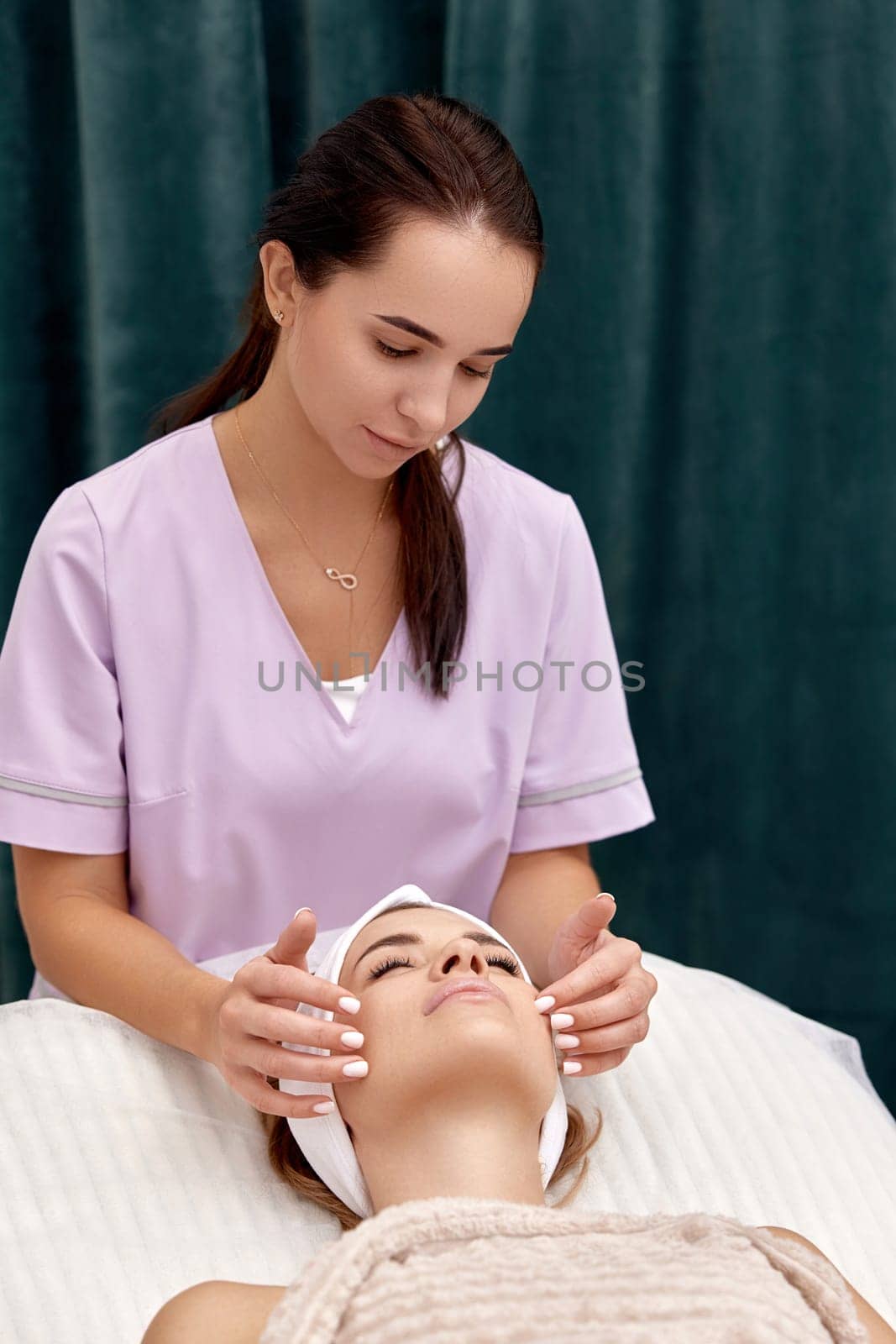 Beautiful woman getting face massage treatment in beauty salon. Skin care.