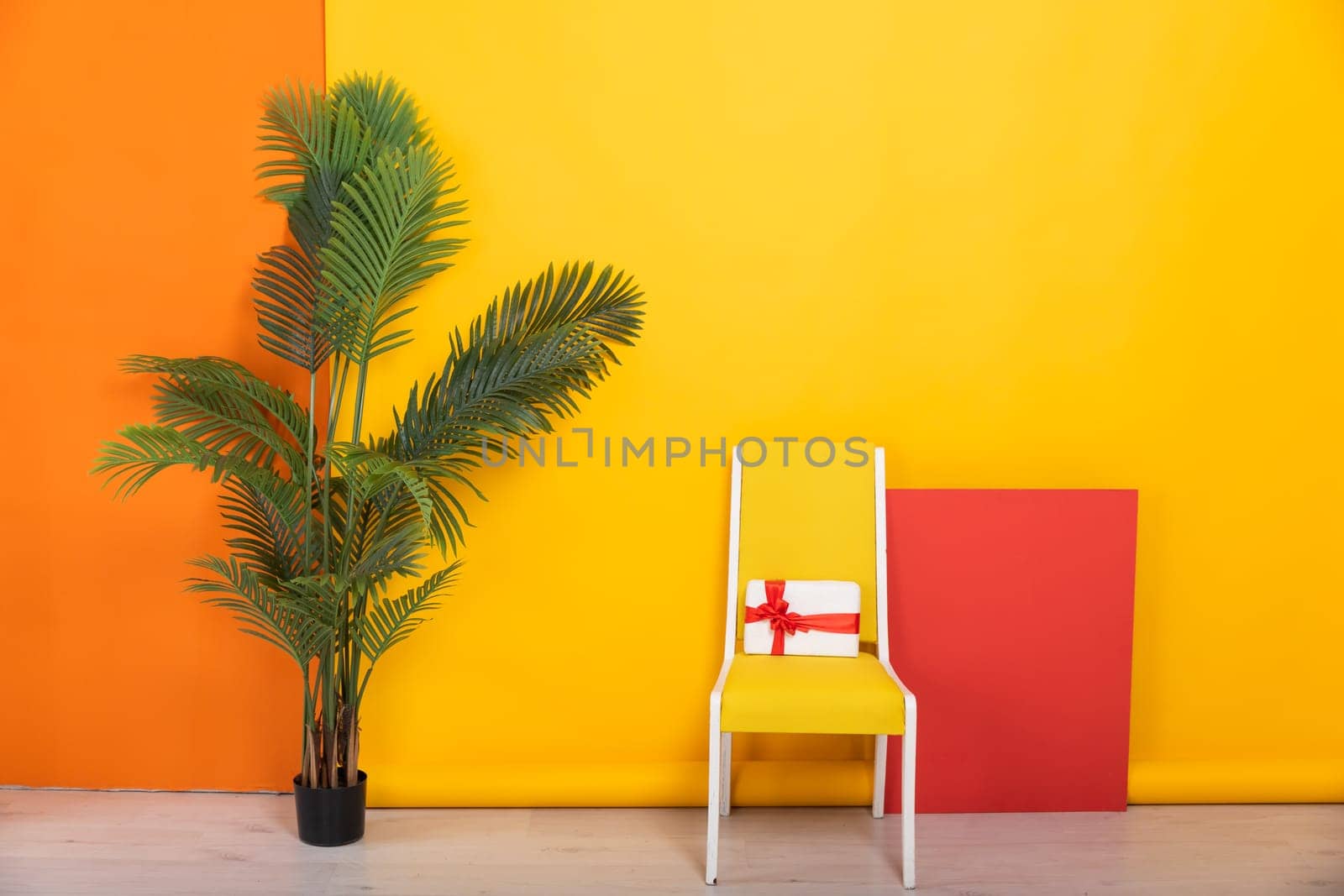 Chair with a gift against a yellow wall