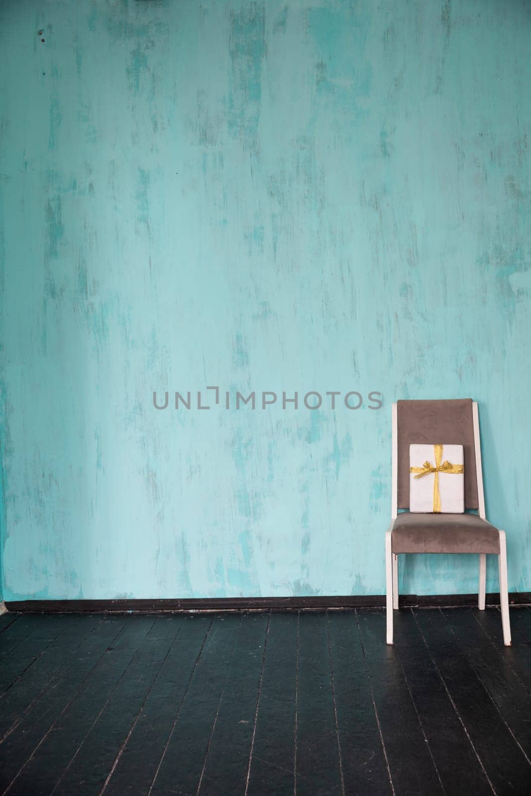 One Chair With Holiday Gift Against Bright Colored Wall by Simakov