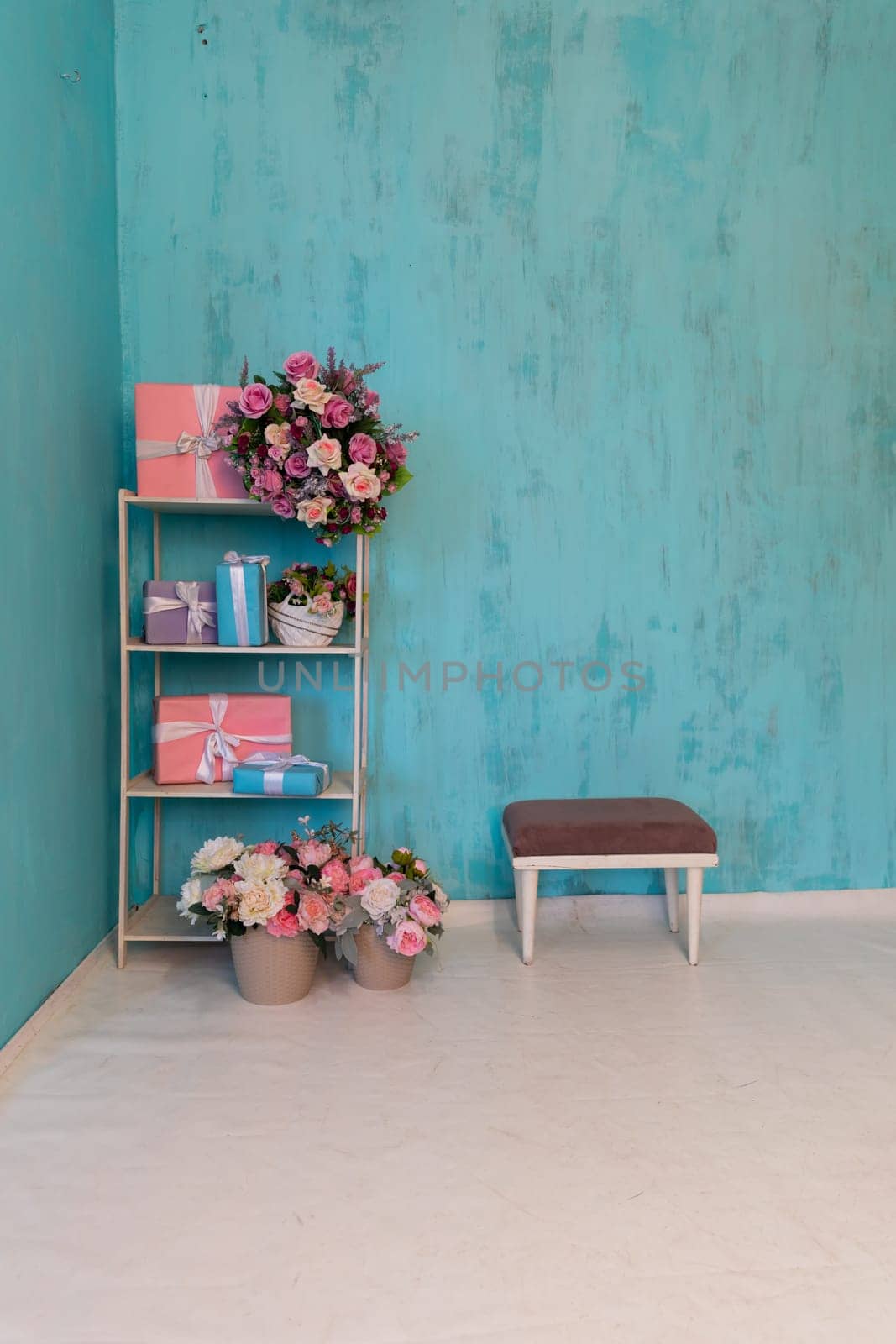 Shelf with gifts and flowers in the interior of a blue room by Simakov