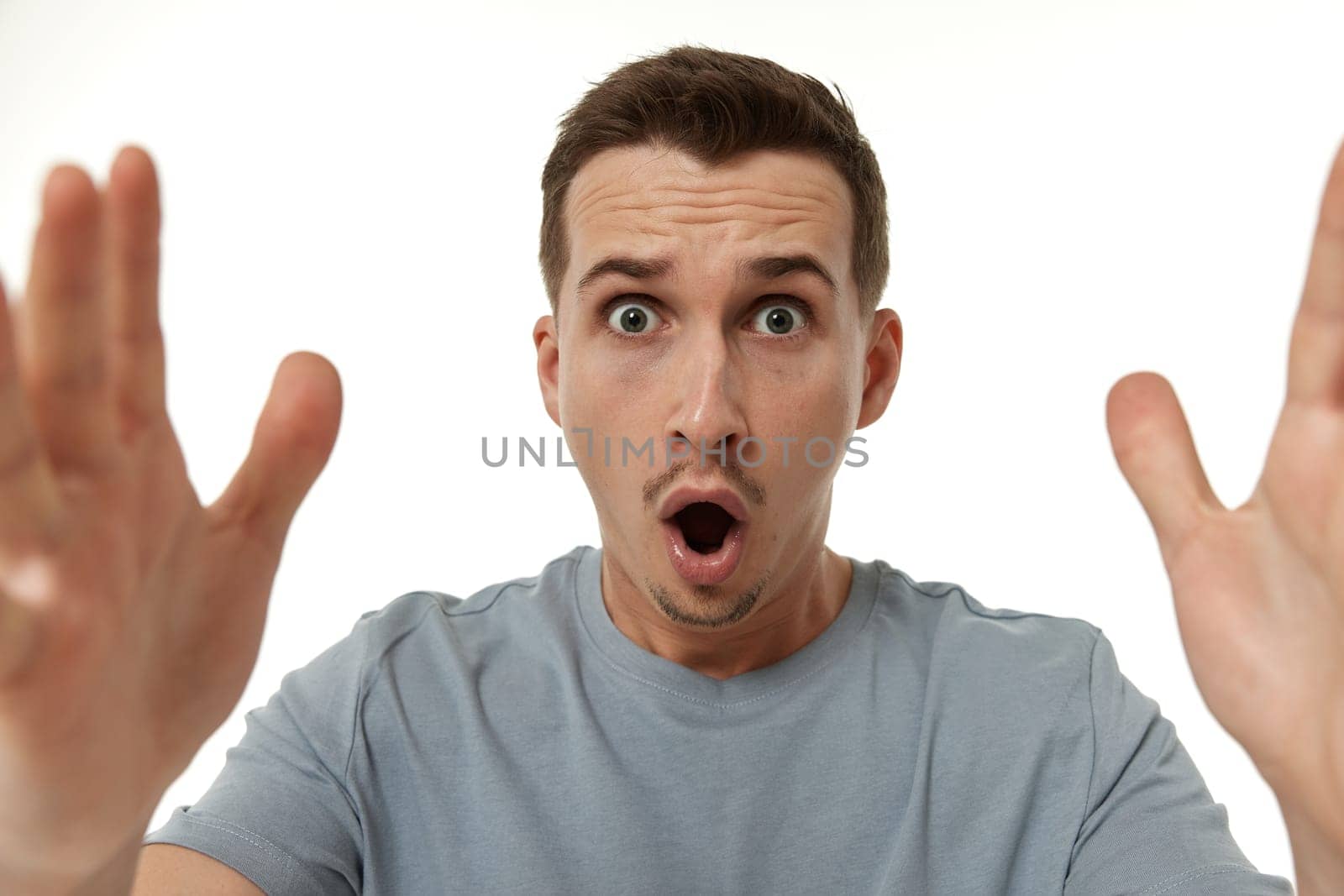 surprised guy looking at camera on white studio background