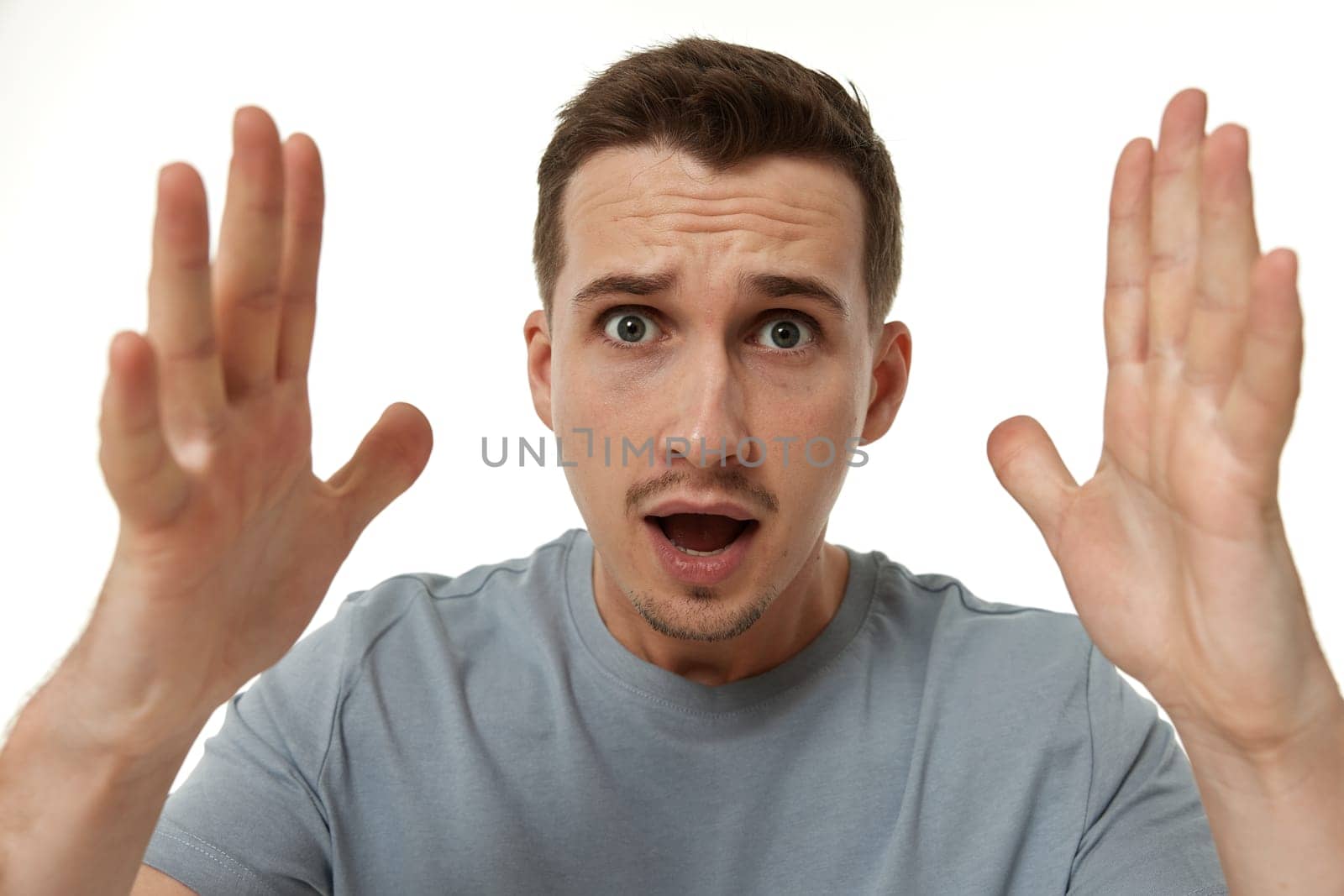surprised guy looking at camera on white studio background