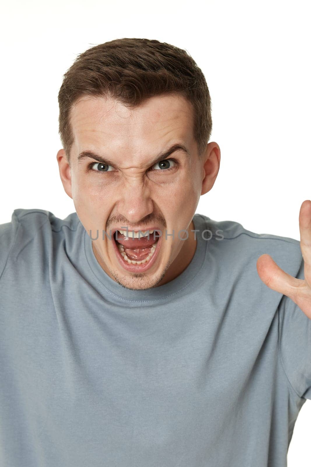 annoyed angry bearded man shouting on white studio background