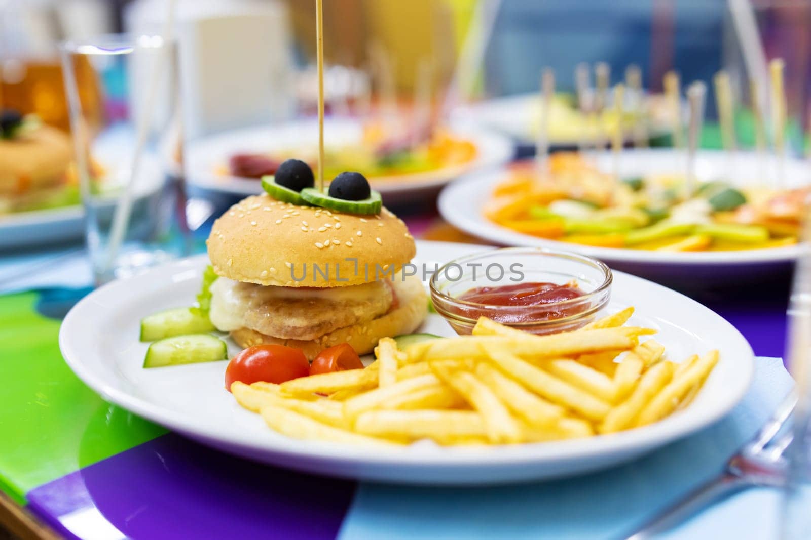 Mini burgers and fried potatoes with sauce on white plate. Kids meal. Kids menu of the restaurant.