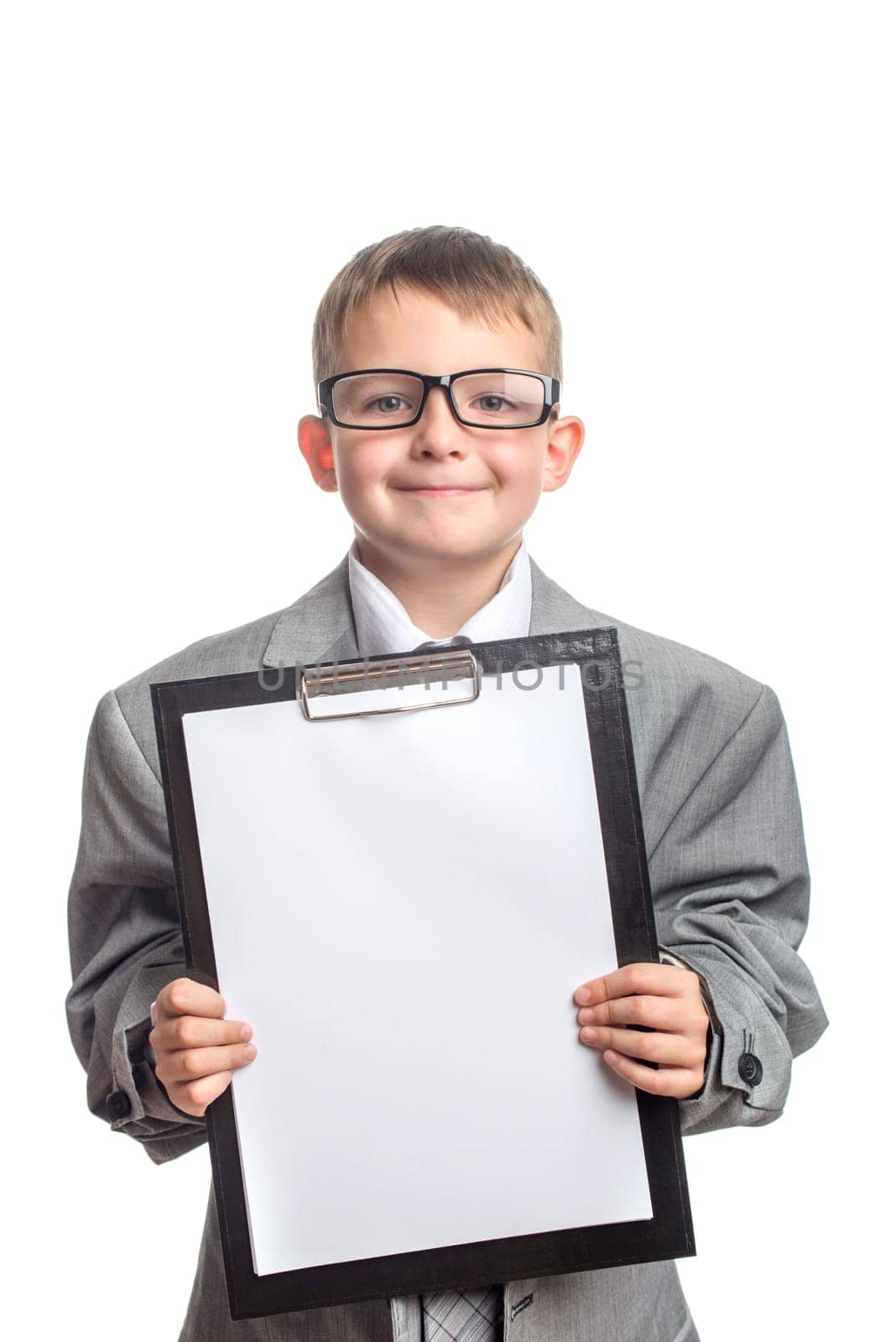 Little cute boy in glasses and a tablet in his hands dressed in a gray suit with a tie on a white background. Advertising of educational courses, advanced training.