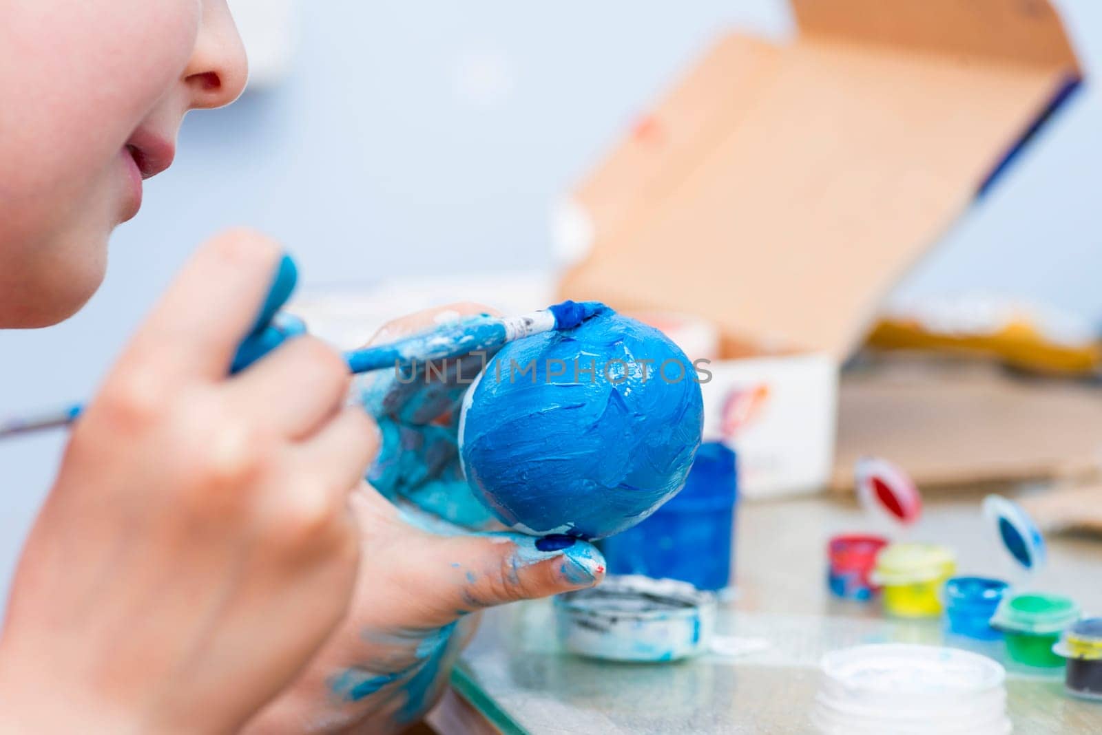 Happy easter. A boy painting Easter eggs at home. A child preparing the easter eggs for Easter.