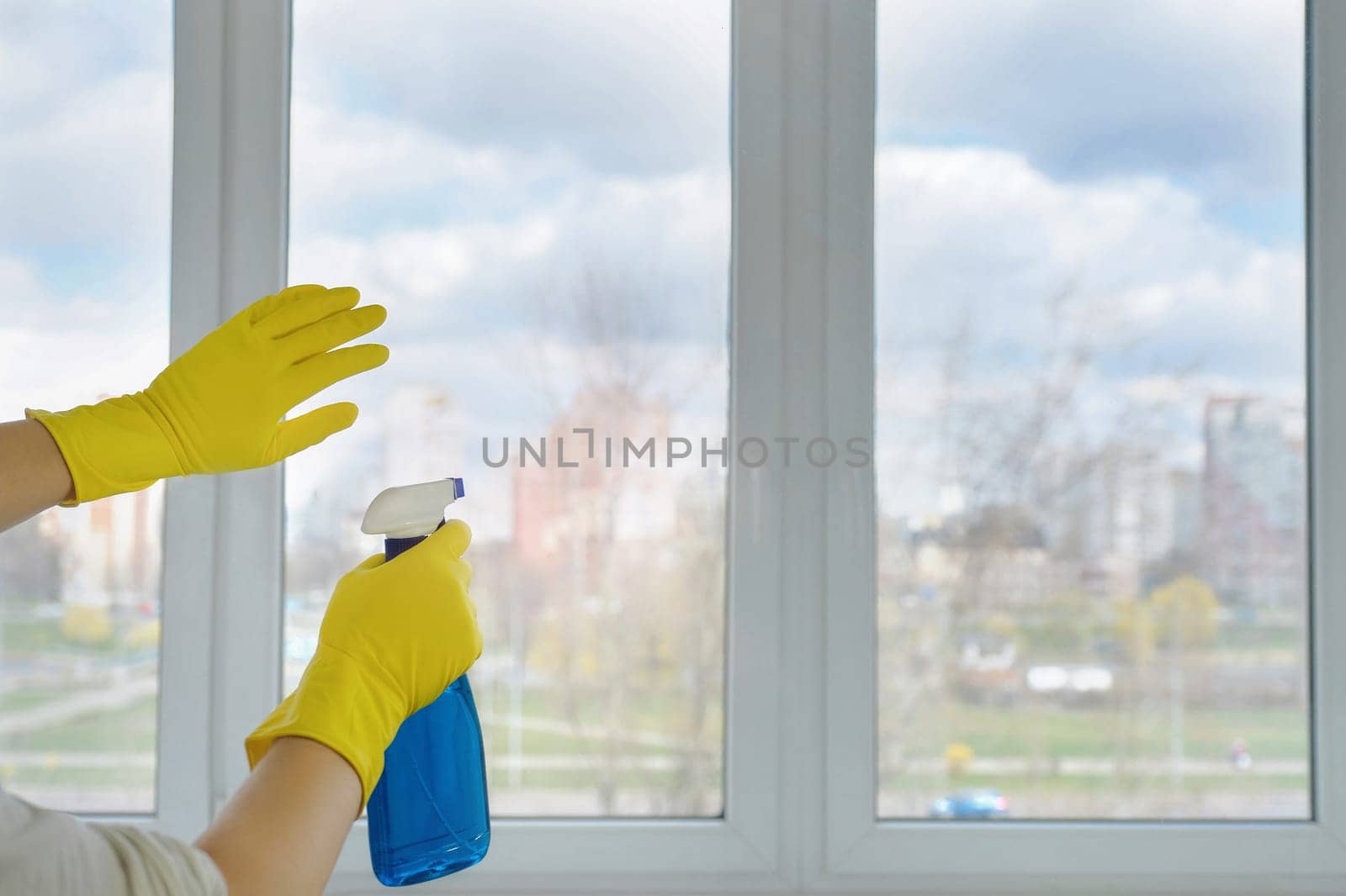 Cleaning window glass with detergent. Hotel cleaning. Cleaning concept by Shablovskyistock