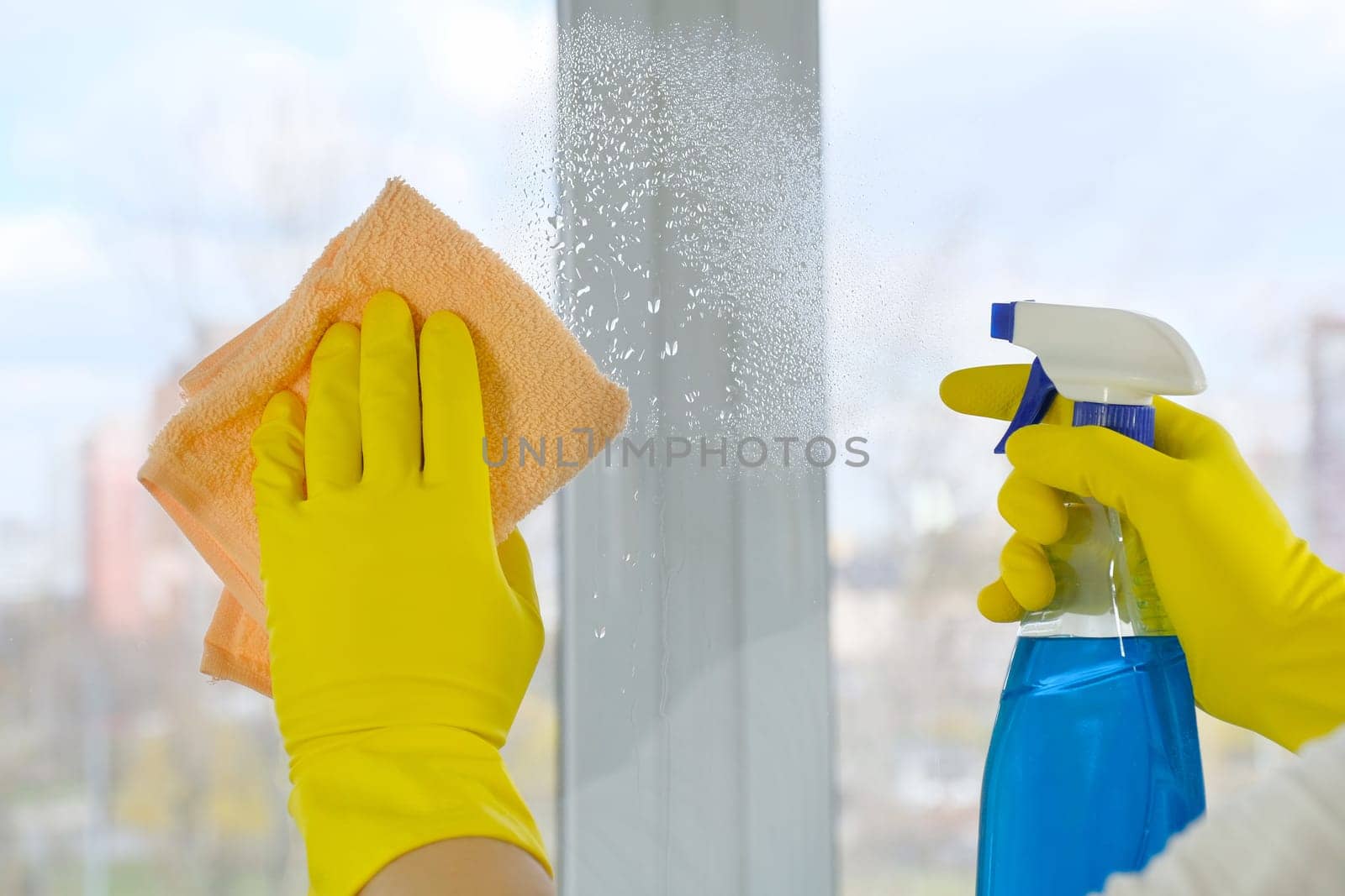 Window cleaning with a rag and detergent. Close-up. Cleaning concept by Shablovskyistock