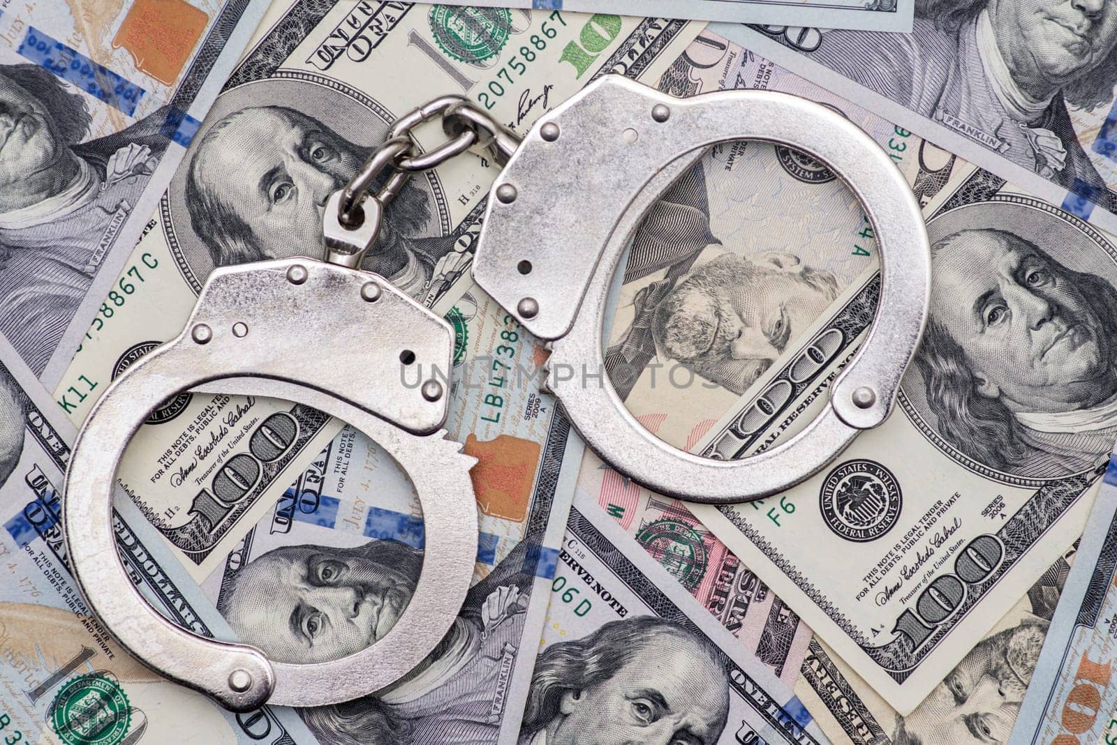 Handcuffs on money background. Dollar bills, money cash corruption, dirty money financial crime and metal police handcuffs.
