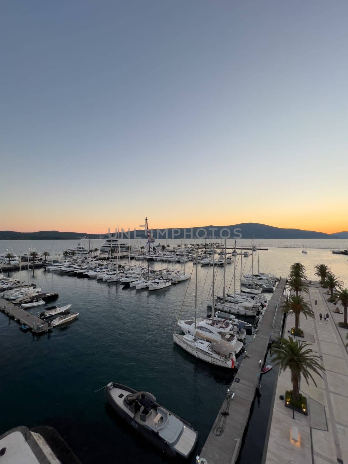 Luxurious marina with yachts at sunset over a mountain range. High quality photo