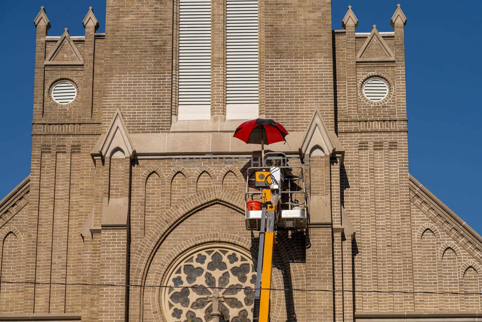 Tradesman working on the pointing between bricks on St Joseph Catholic Church in Greenville, Mississippi on power lift