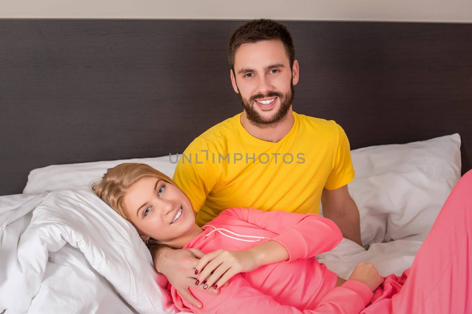 Young lovely couple lying and have fun in a bed by nazarovsergey