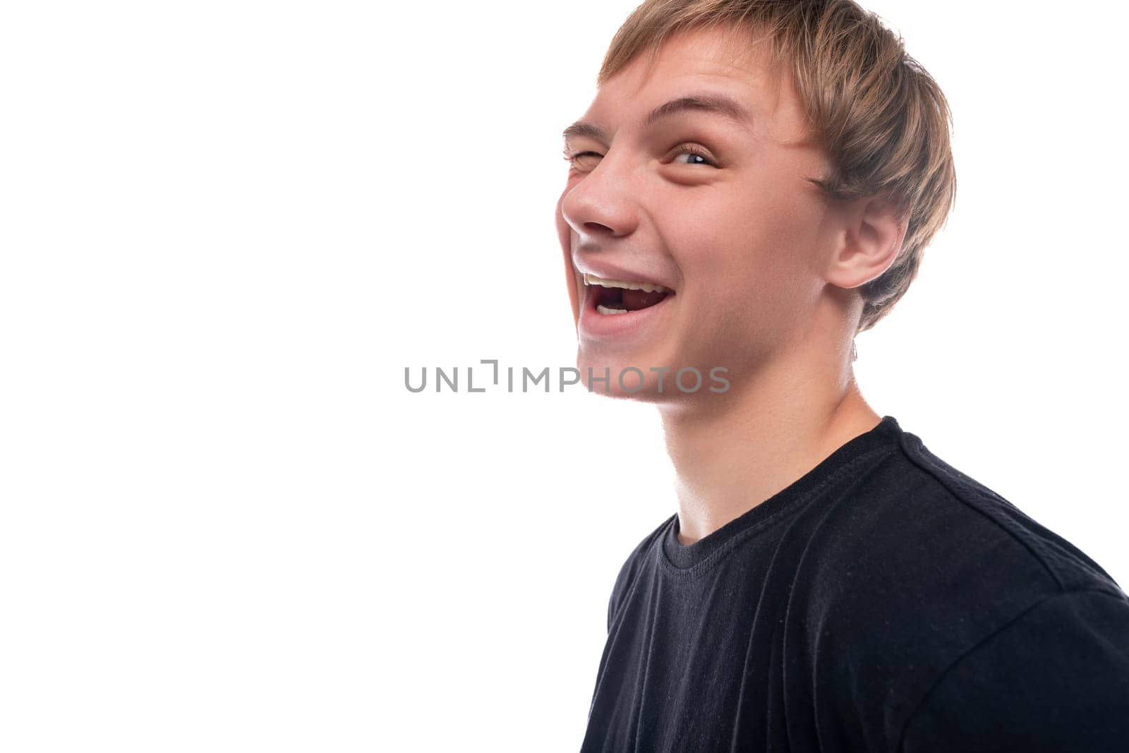 Charismatic teenage guy with blond hair makes a grimace.