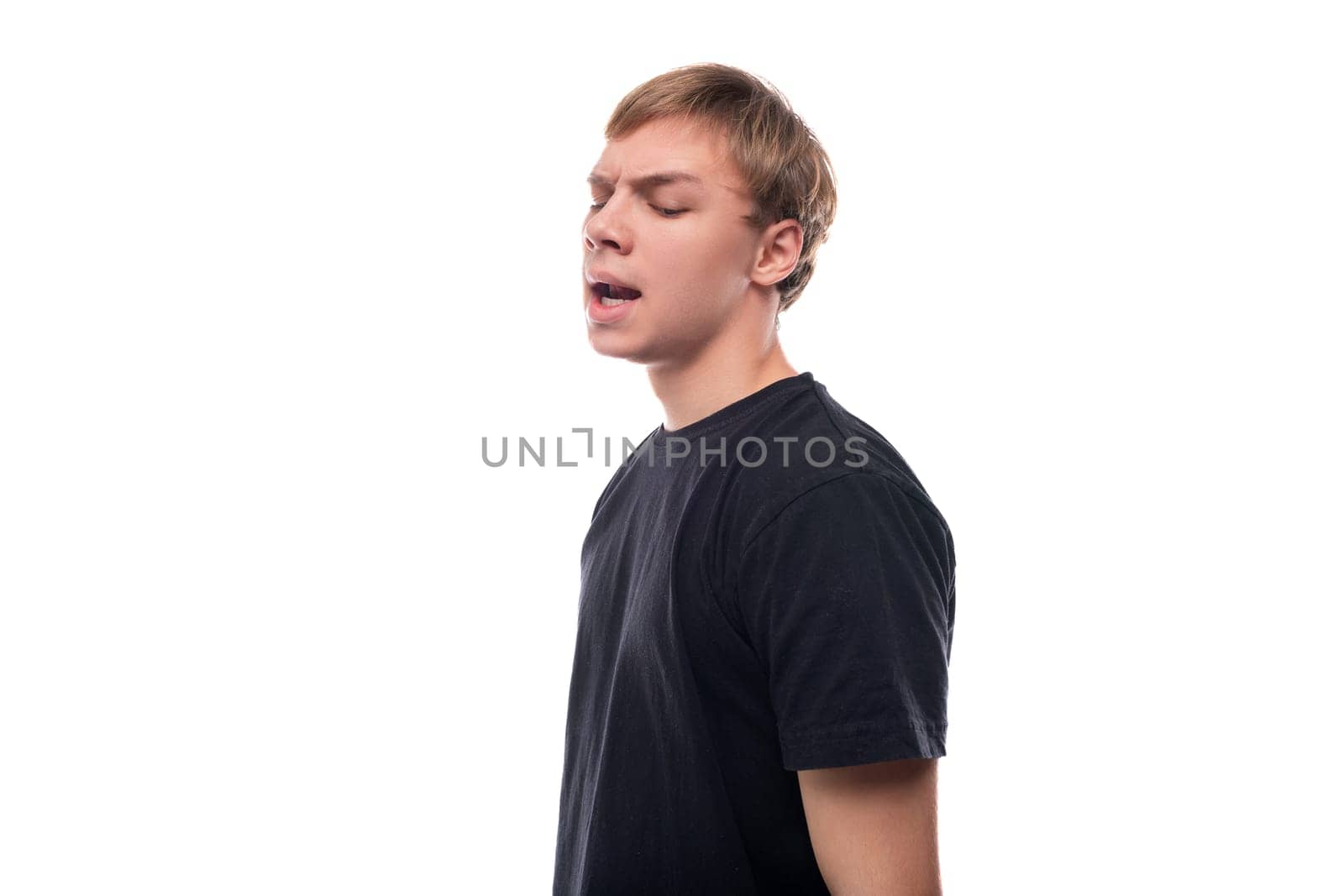 Portrait of a charming teenage guy with brown hair telling something.