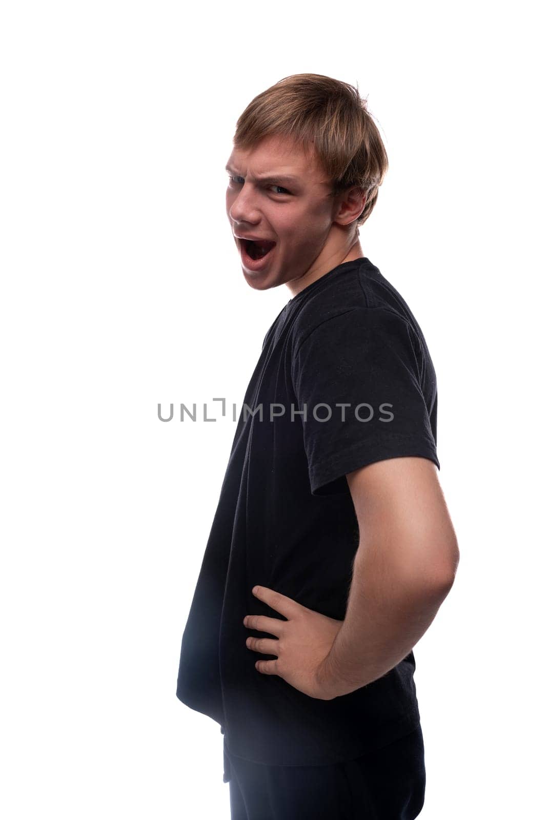 Charismatic teenage guy with blond hair makes a grimace by TRMK