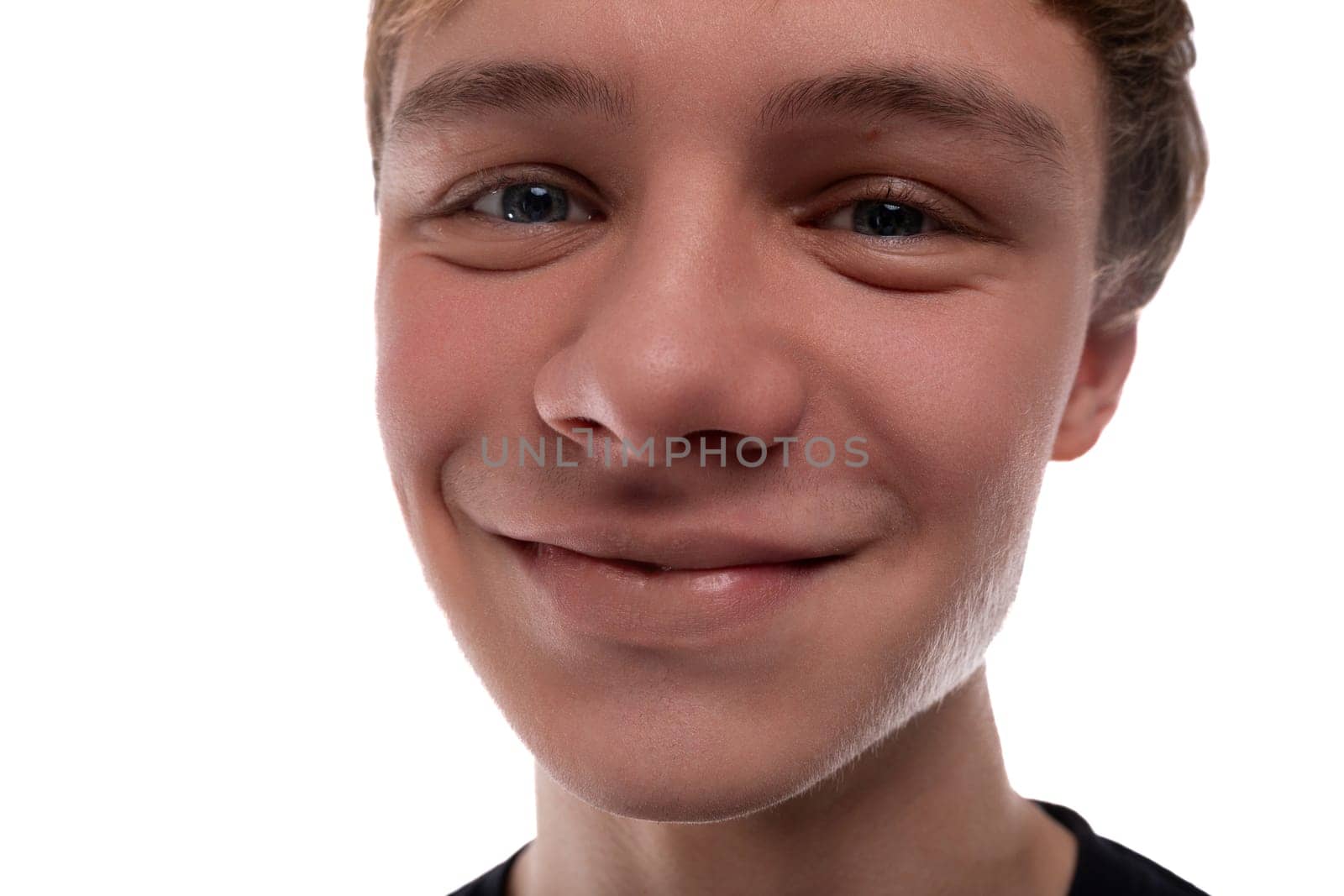 Caucasian blond 16 year old guy dressed in a black T-shirt close-up, cute smile.