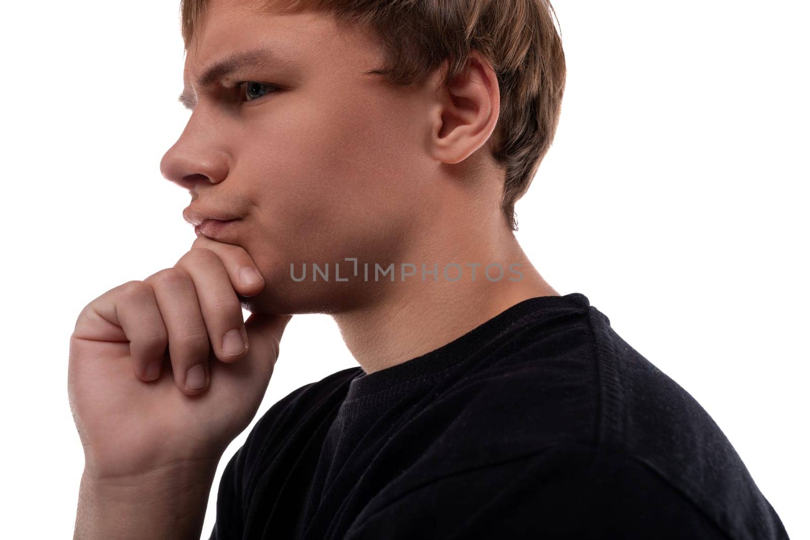 Close-up portrait of a pensive teenage guy with brown hair.