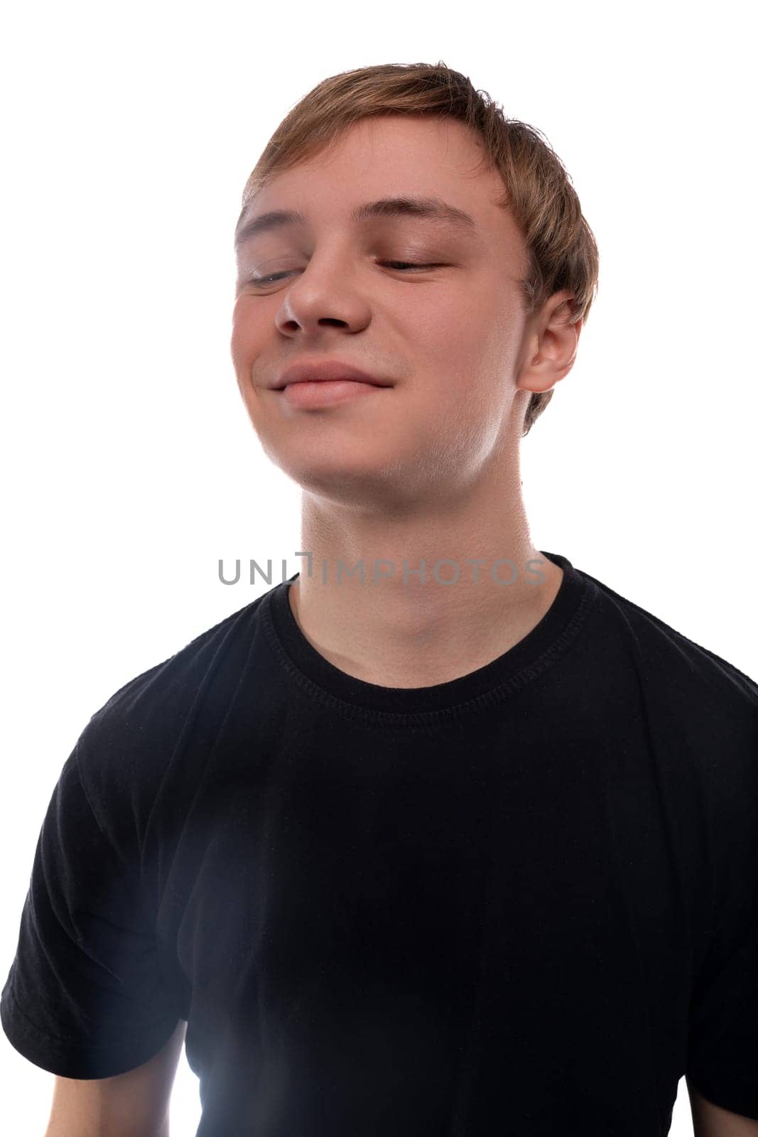 Cute fair-haired teenager guy on a white background, close-up portrait.