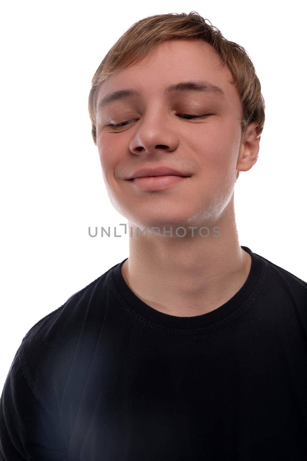 Close-up portrait of a blond 16 year old teenage boy against a background with copy space.