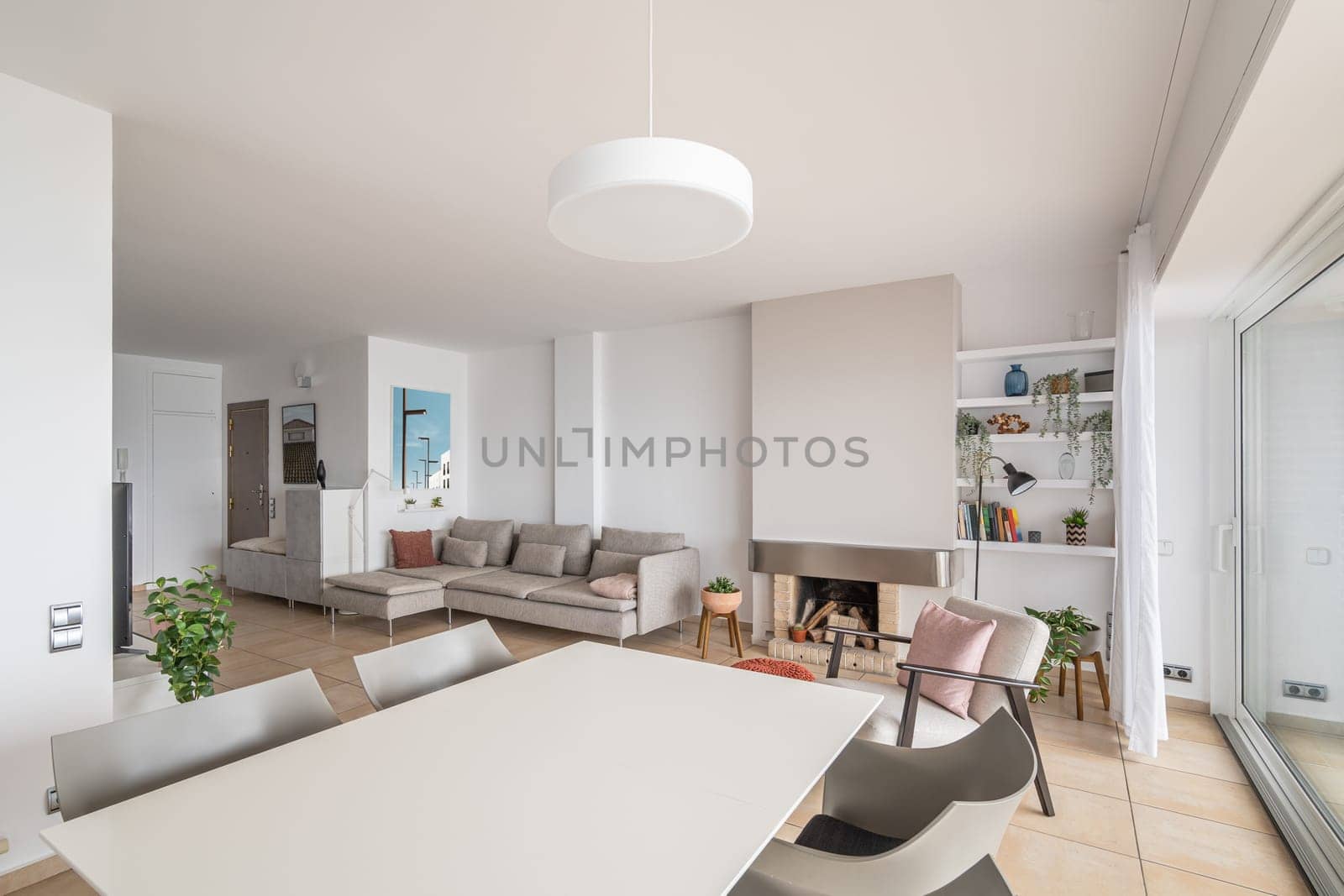 Dining table and and fireplace in renovated smart apartment. Presenting idea of home space organization in residence. Minimalist house design