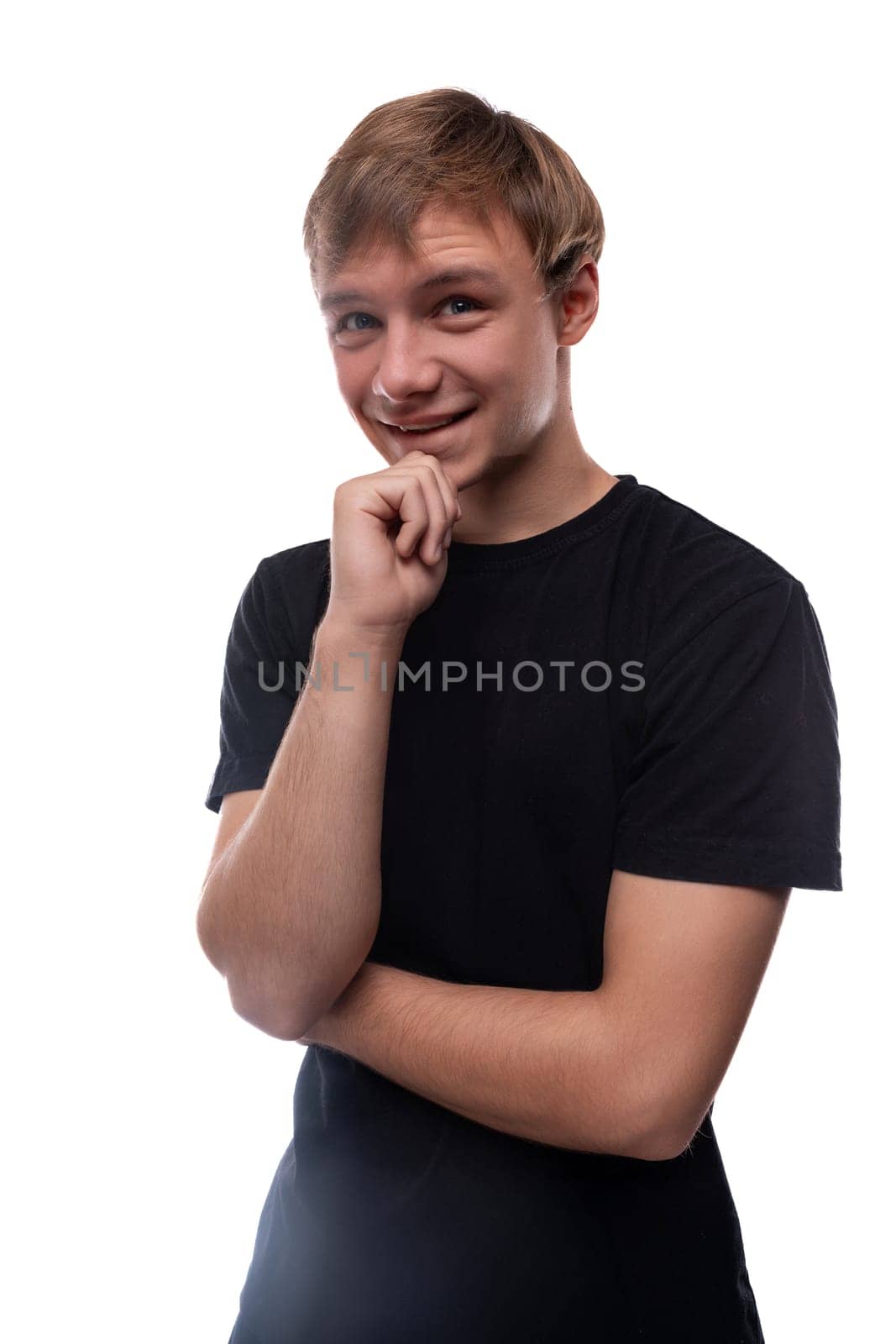 European blond teenager boy dressed in a black T-shirt smiling and happy.