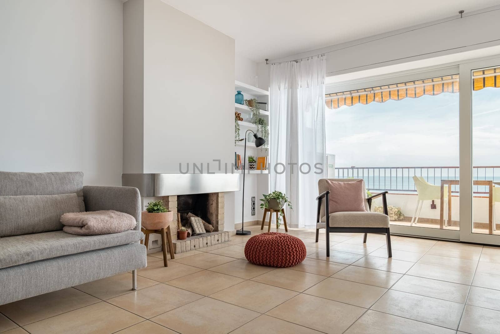 Fireplace creating coziness and comfort in studio apartment. Stylish residential house with large terrace by sea for tourist rent. Home comfort