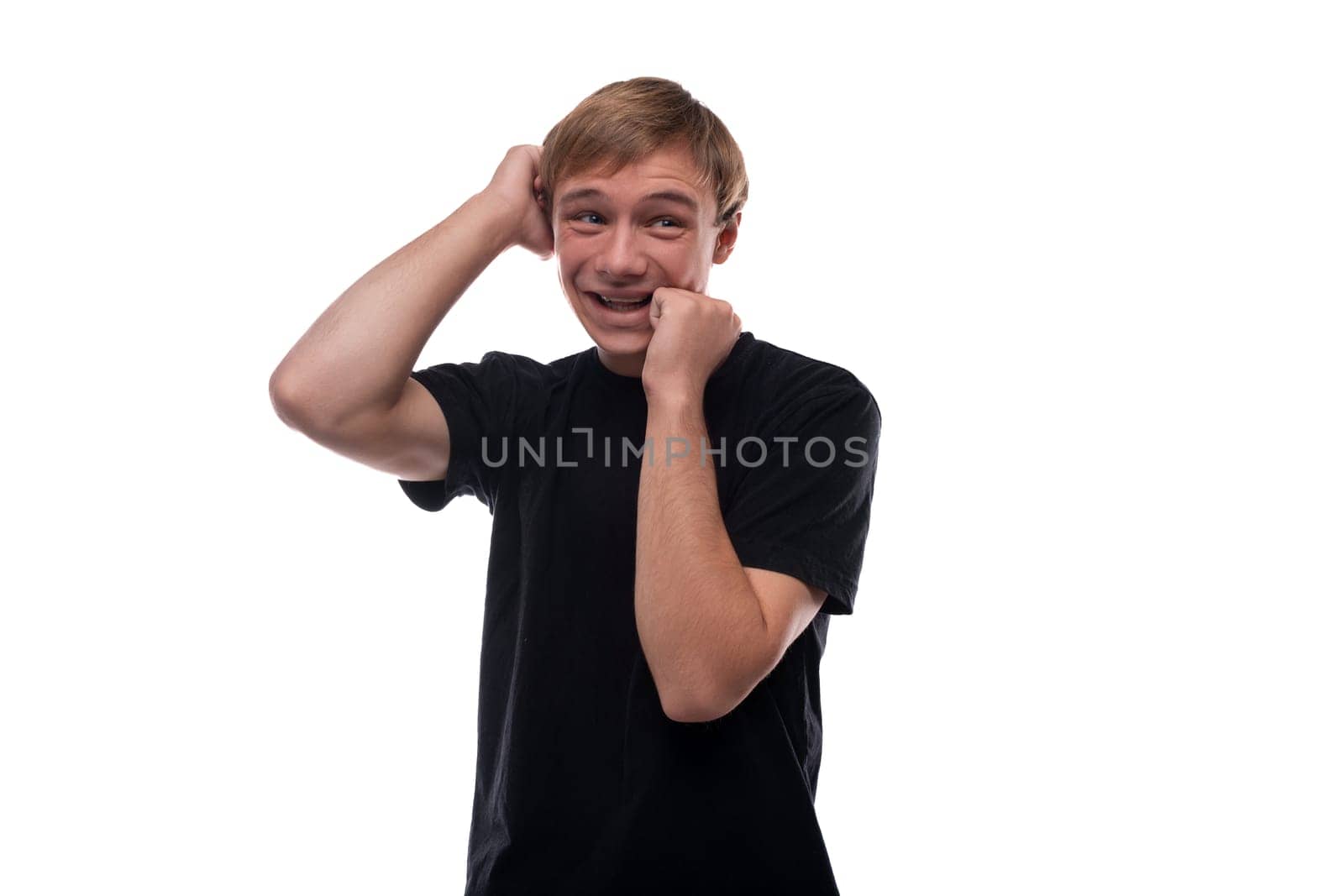 Portrait of a European handsome blond teenager guy in a black T-shirt.