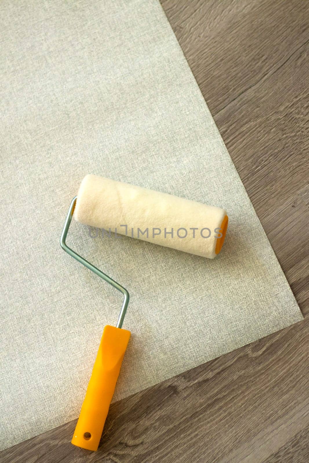 Gray textured wallpaper rolls on wooden background. copy space. Professional Wall Paint Roller Brush Handle Tool Replacable. Portable Sponge Paint Roller Brush Handle DIY Wall Painting Tool Wall Decor