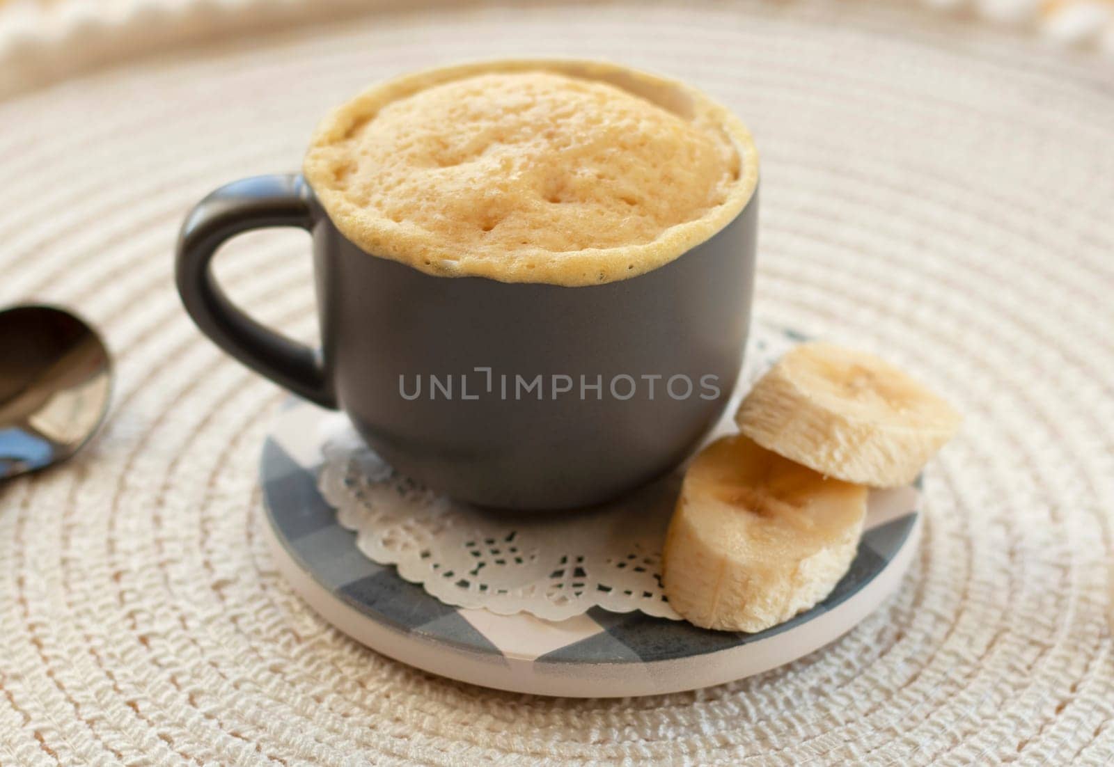 selective focus. homemade Portioned Banana bread mugcake in small mugs. Easy sweet baking in the microwave idea, With fresh bananas, nuts. Muffin with banana slices cooked in a mug. copy space.