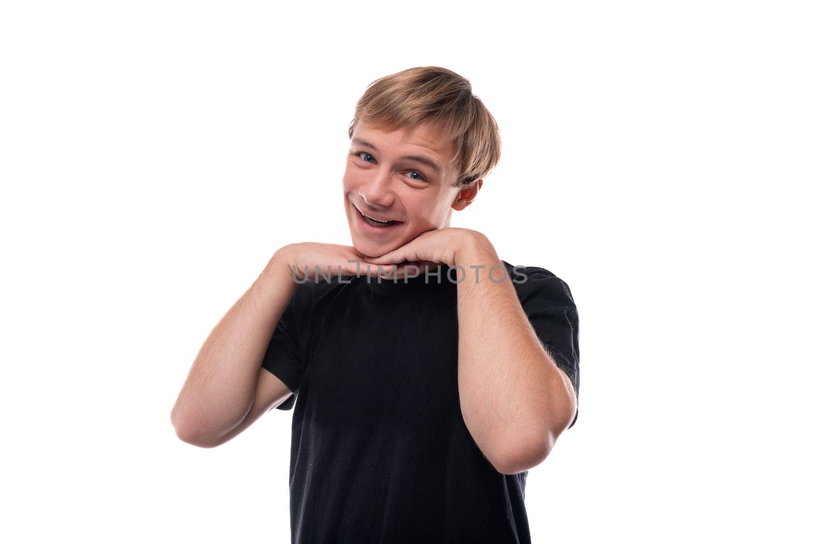 Portrait of a cute teenage guy with blond hair on a white background.