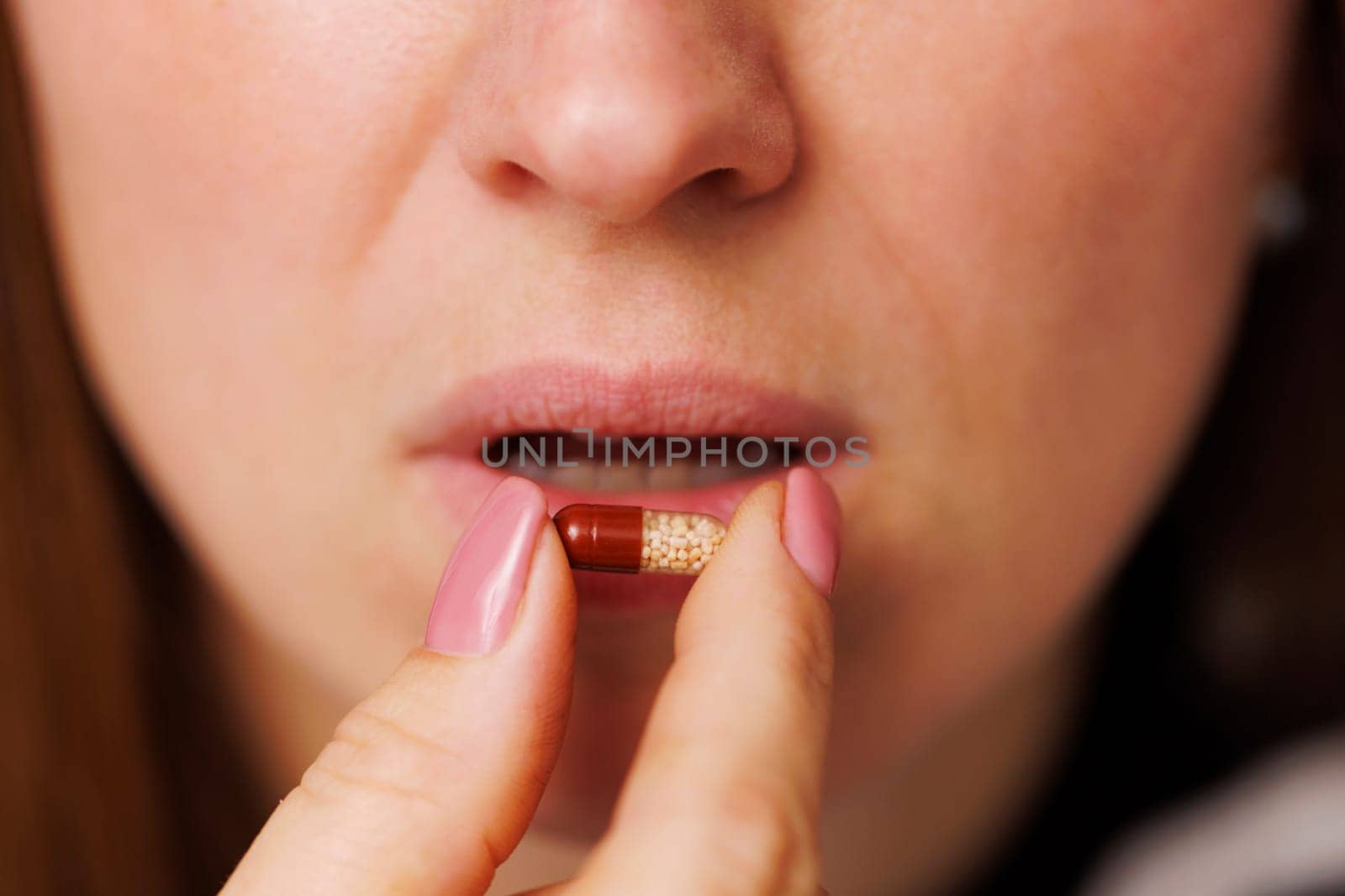 Closeup of young woman takes pill. Antibiotic or antidepressant, vitamins for health care or contraceptive